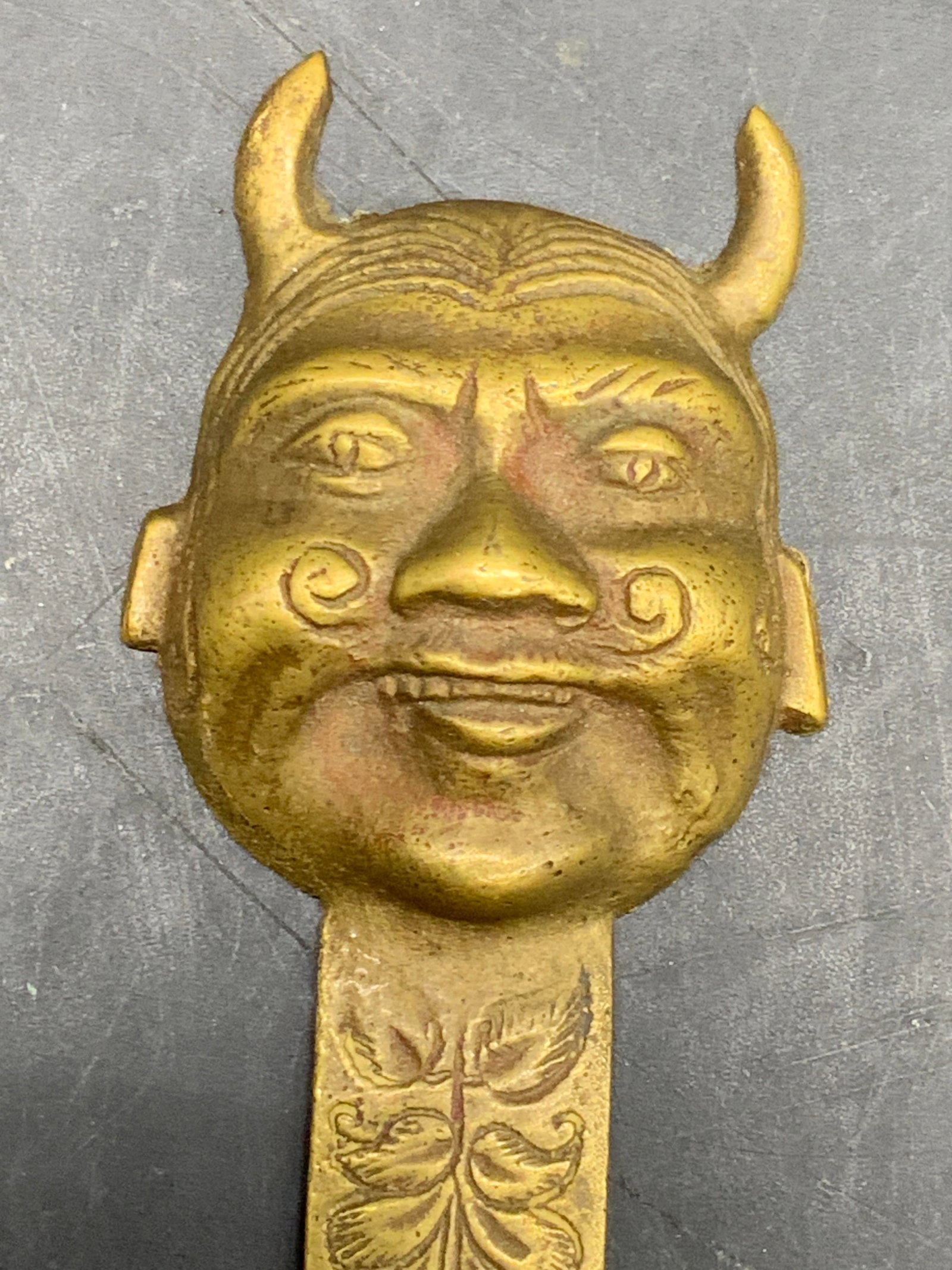 Brass Horned Figural Head Letter Opener: A brass figural head letter opener featuring etched brass work along the blade. Reverse marked India. Piece measures approx. 8.5L x 1.25W in. Discoloration, scratches, and surface wear present. Some w