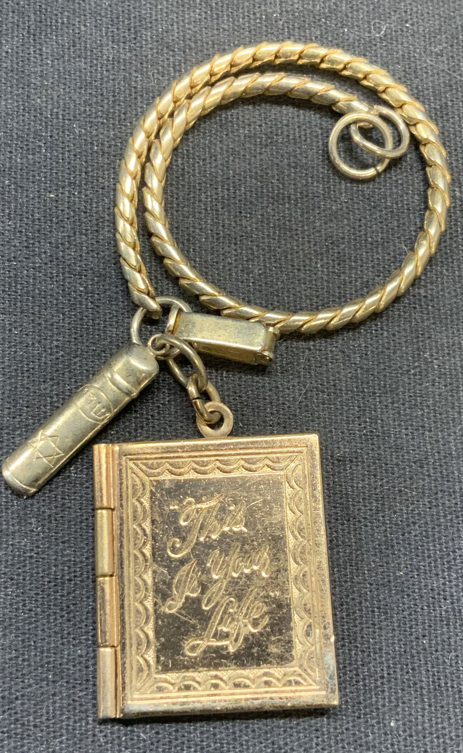 Vintage Gold Tone Judaica & Book Locket Pendant: Vintage gold tone book locket pendant and Judaica motif pendant on gold tone chain. Book pendant measures approx. 1 x 7/8 inches. Chain measures approx 6 inches long. Some surface wear including scrat