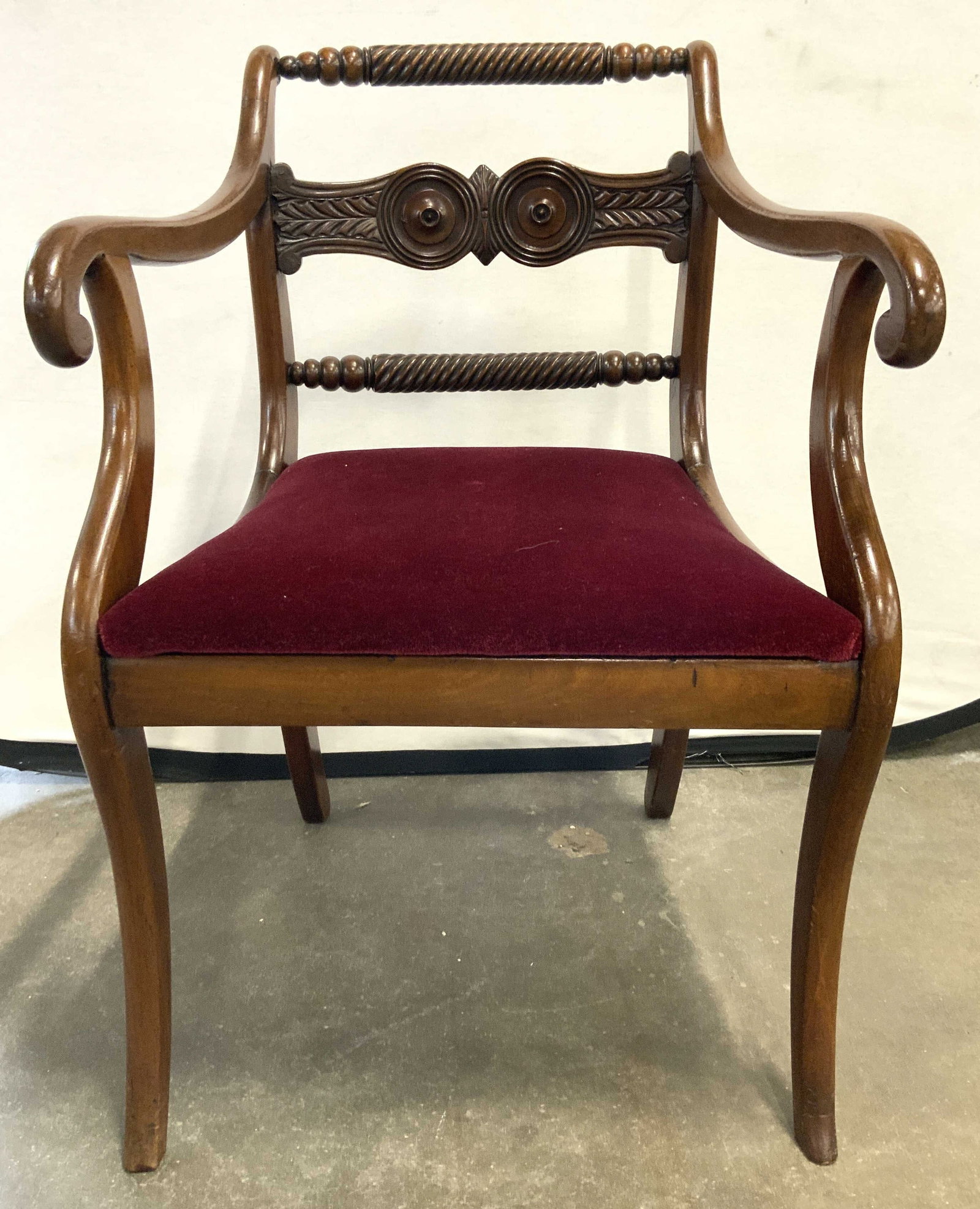 Antq Regency Wooden Scroll Arm Chair C 1860s: Chair appears to be antique circa 1860s. Chair has scrolled arms. Chair frame is wooden. Piece has cranberry toned crushed velvet upholstery. Backrests have intricately carved detail. Chair measures a