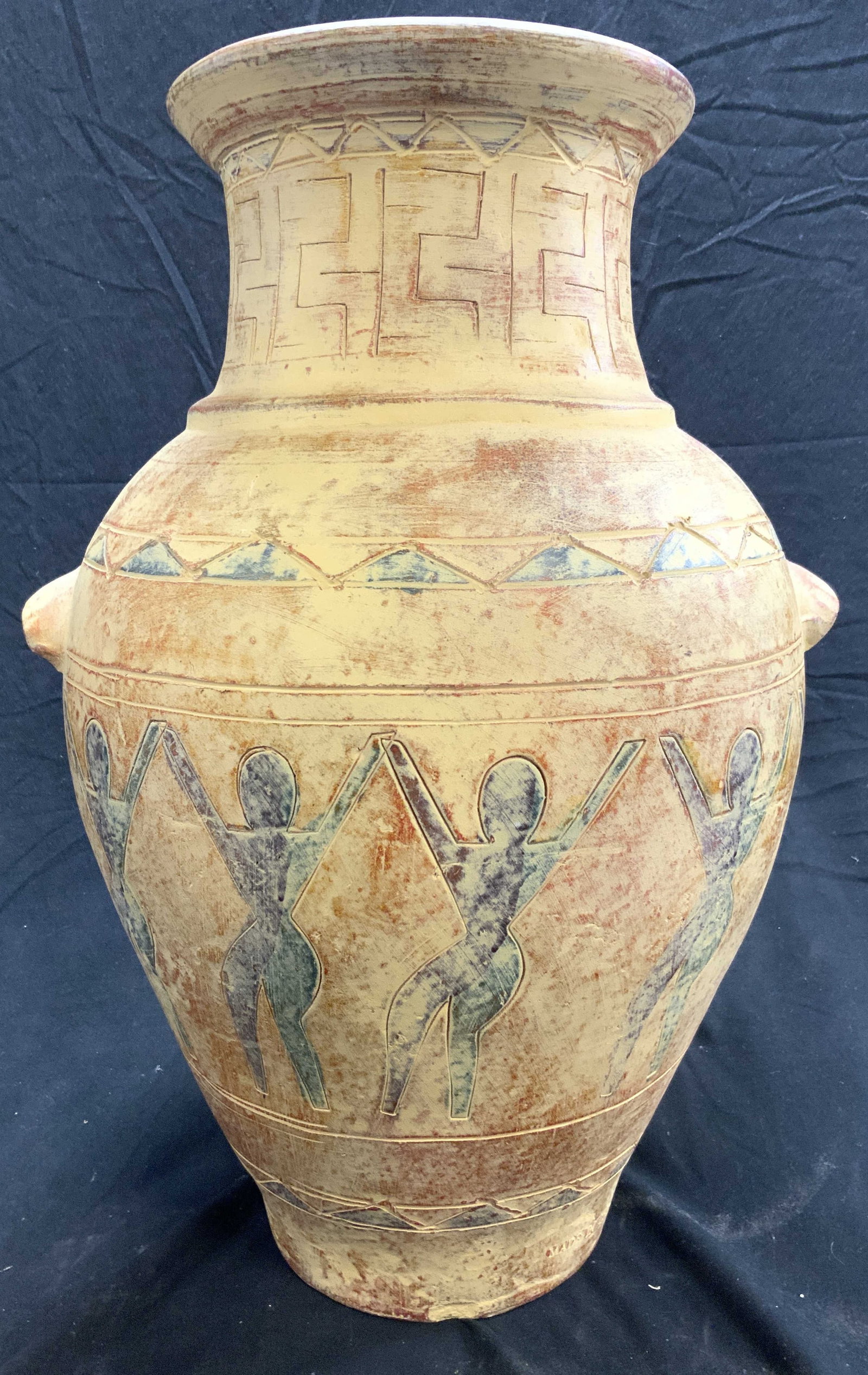Ceramic Dancing Tribal Women Vase W Handles: Vase is ceramic. Piece has tribal detail. Geometric patterns and female figures dancing with arms raised. Vessel is sand and terra cotta toned. Vase has handles at sides. Piece measures approximately 