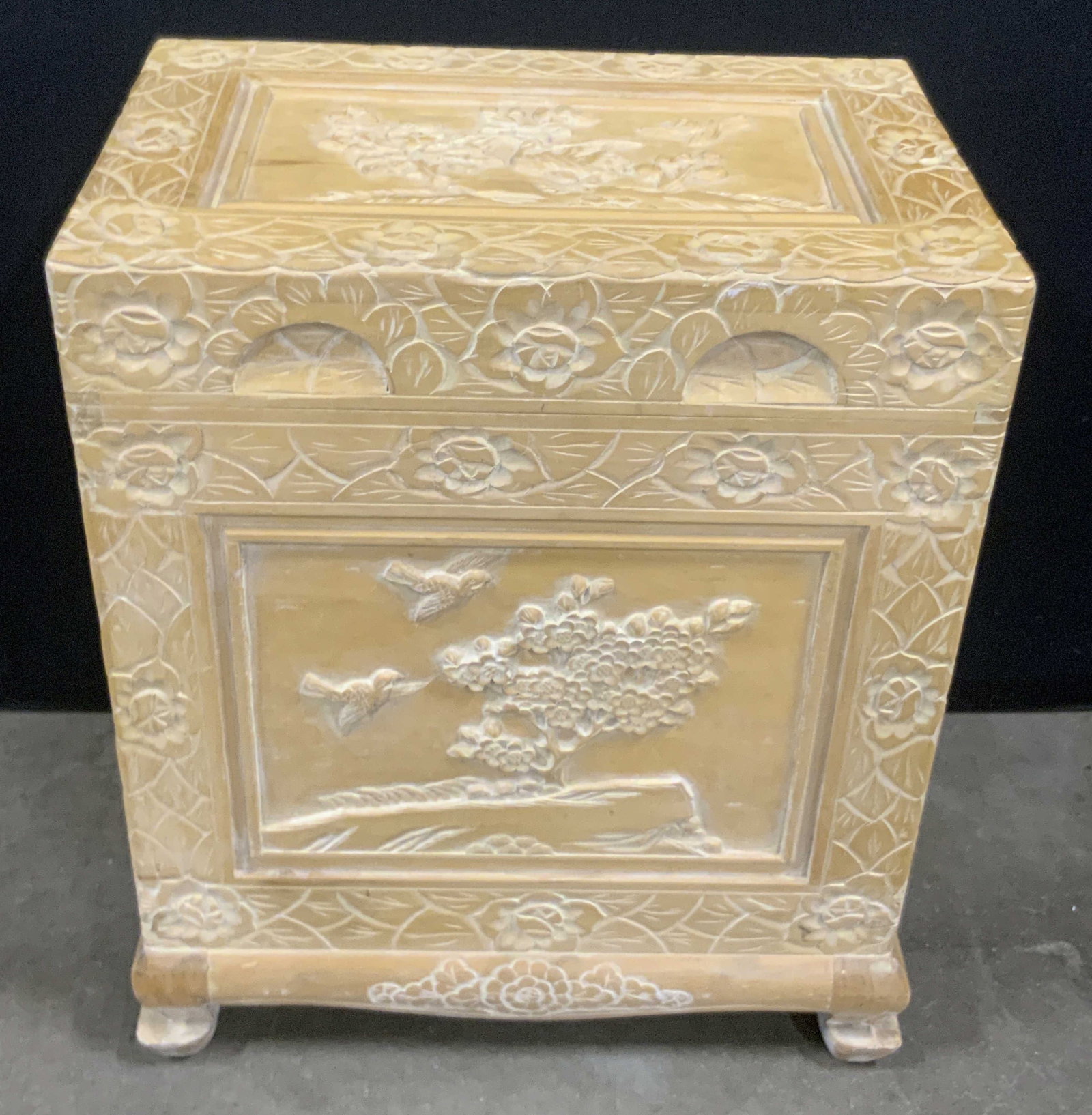 Vintage Asian Carved Wood Hinged Chest: A vintage Asian carved wood chest with a lid that opens with hinge hardware. Four feet to the chest. Motifs depicting florals, foliage, birds, and more decorate the sides. Light hued wood. Dovetailing