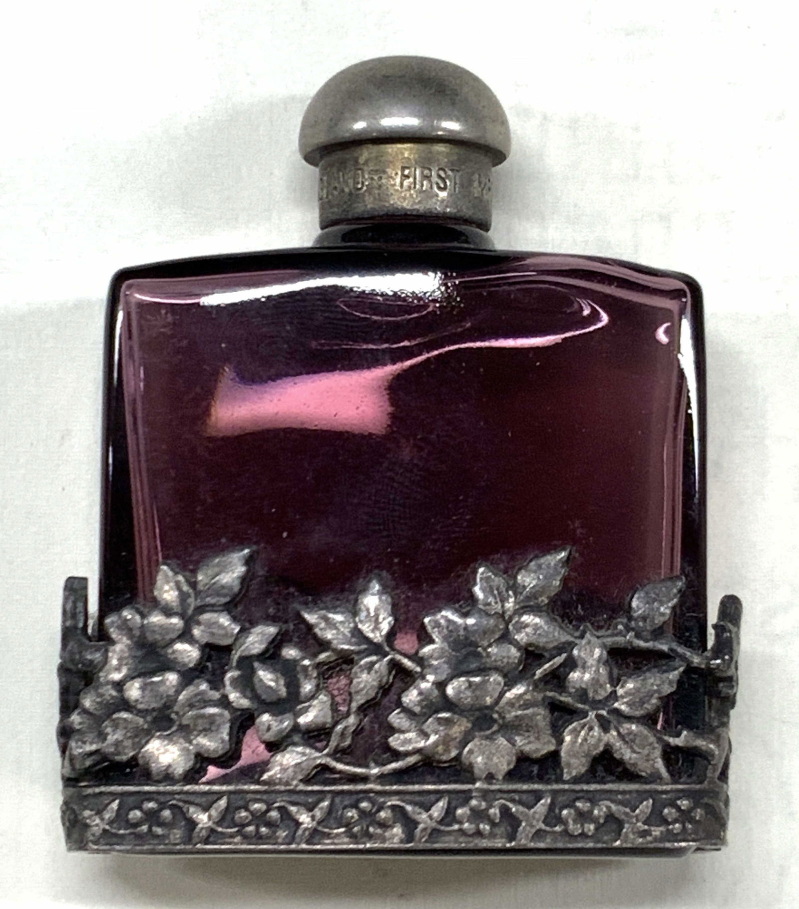 First Impressions Vintage Glass Perfume Bottle England: Marked on bottomless first impressions, Made in England. Purple toned glass bottle with pewter floral lower half. Approx 2.5 x 2 inches. Moderate wearing to glass and to pewter accent. Vintage perfume