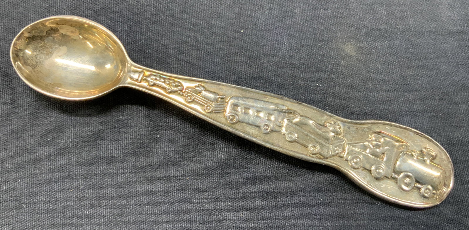 Vintage Tiffany & Co Sterling Silver Child Spoon: Marked on handle Tiffany & Co 925. Child spoon with raised motifs of toy trucks and a trains on handle. Approx 6 inches long. Total weight of sterling is 1.68 ozt Moderate wearing to sterling due to a