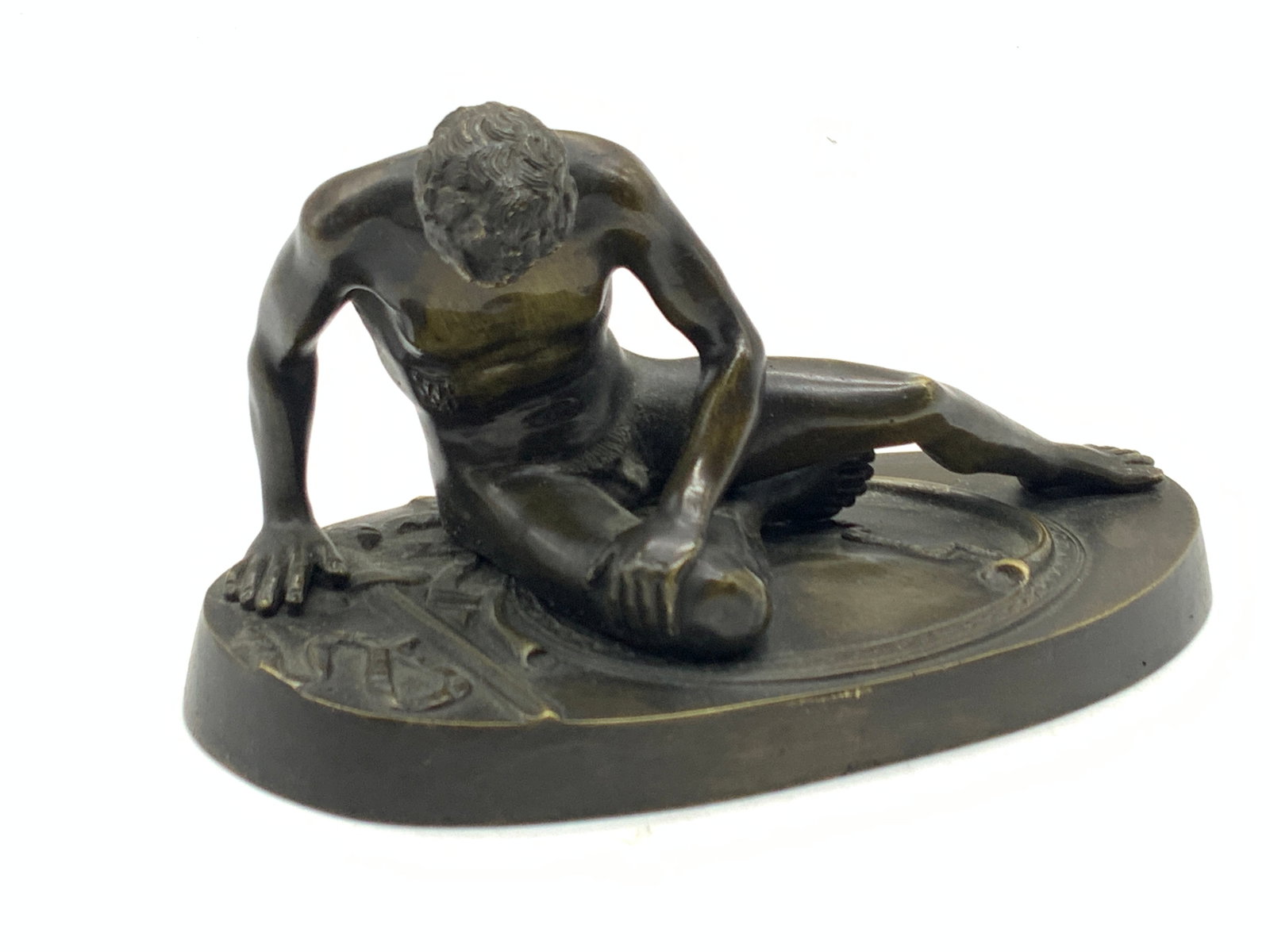 Cast Brass The Dying Gaul Figure: Cast patina brass figure of the Dying Gaul, presenting the dying Gladiator nude on a base with a cut in his torso, a whip and sword beneath him. Approx 3.75 inches tall and 6 inches long and 3 inch wi