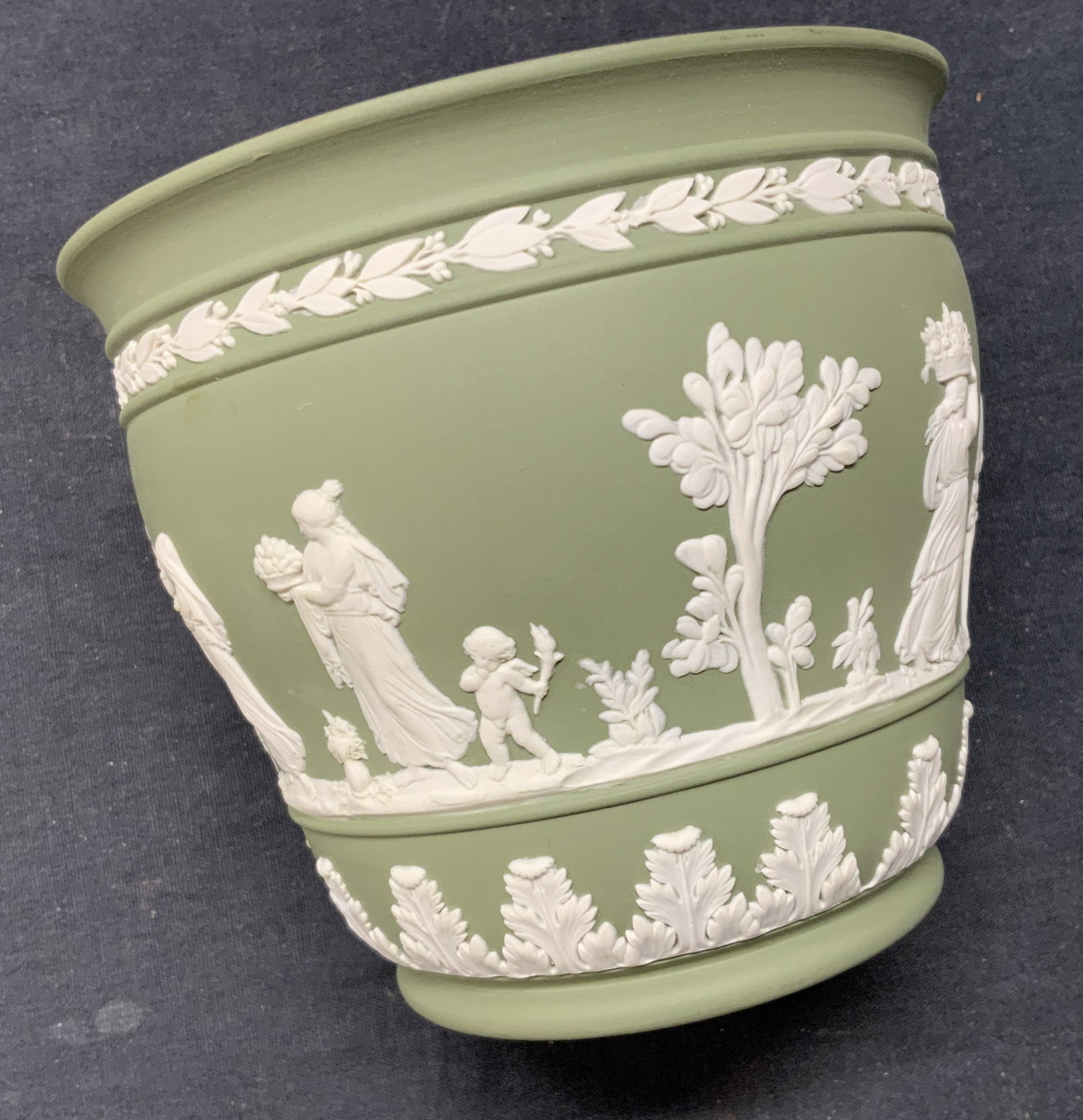 Wedgwood Neoclassical Porcelain Cachepot, England: Wedgwood porcelain cachepot with Laurel and Greco - Roman cherubs and Figurals. Marked Wedgwood- Made in England and dated 1956 .Measures 4.25 in, ht., 5 in diameter. Vintage Wedgwood Cachepot, Green 