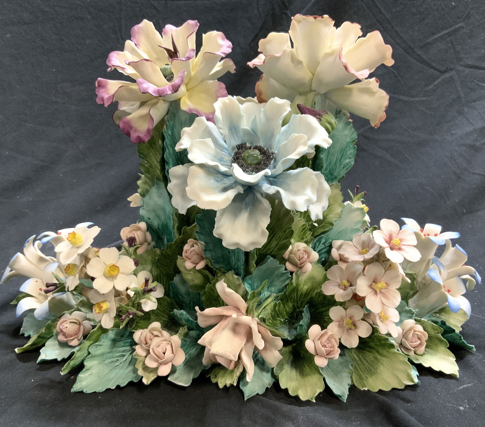 CAPODIMONTE VISCONTI MOLLICA Porcelain Flowers: Underside is marked CAPODIMONTE VISCONTI MOLLICA. Arrangement of multi toned flowers & leaves. Piece is porcelain, appears to possibly be hand painted. Measures approximately 15 inches long 10.25 inch