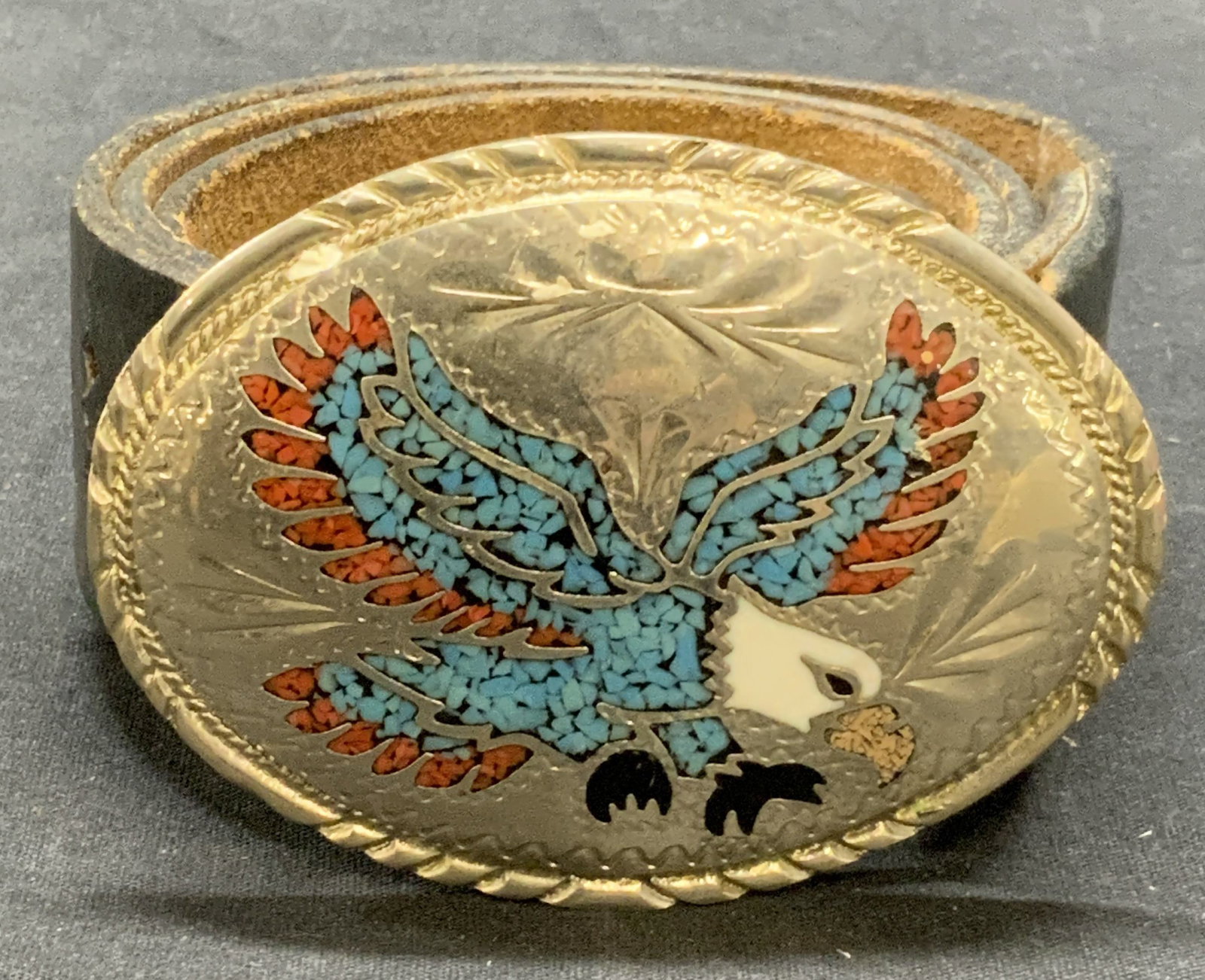 SSI Turquoise & Coral Eagle Buckle & Leather Belt: Vintage black leather belt and SSI metal belt buckle with turquoise and coral decorated eagle motif. Trademarked to underside of belt buckle. Buckle measures approx. 3.75 x 3 inches. Belt measures app