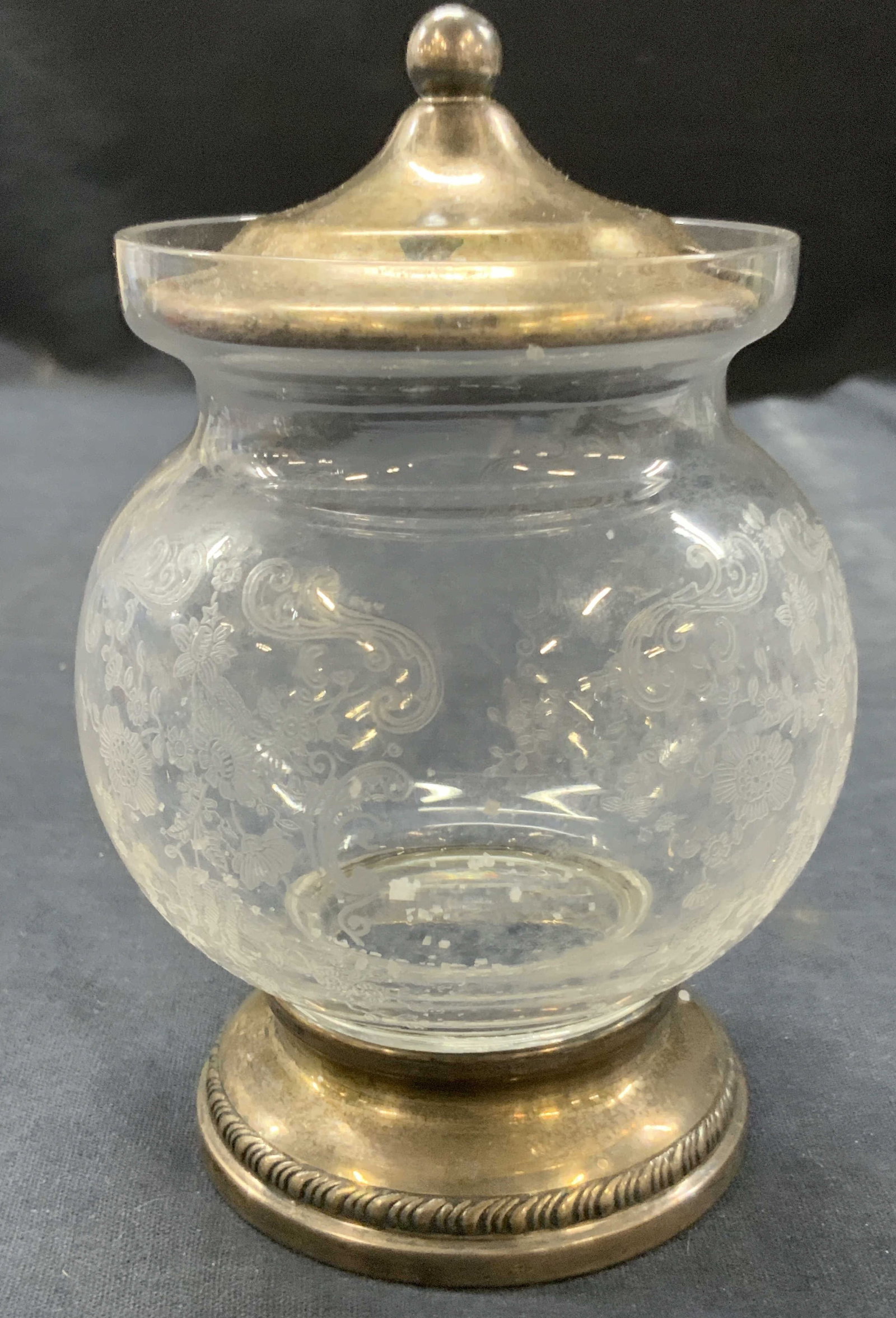 Sterling Silver Overlay Etched Glass Vessel: Vessel with sterling silver stamped overlay base and on lid, body to vessel is etched glass with floral and scroll motifs throughout, approx 6 inches tall and 3 inch diameter Moderate wearing to sterl