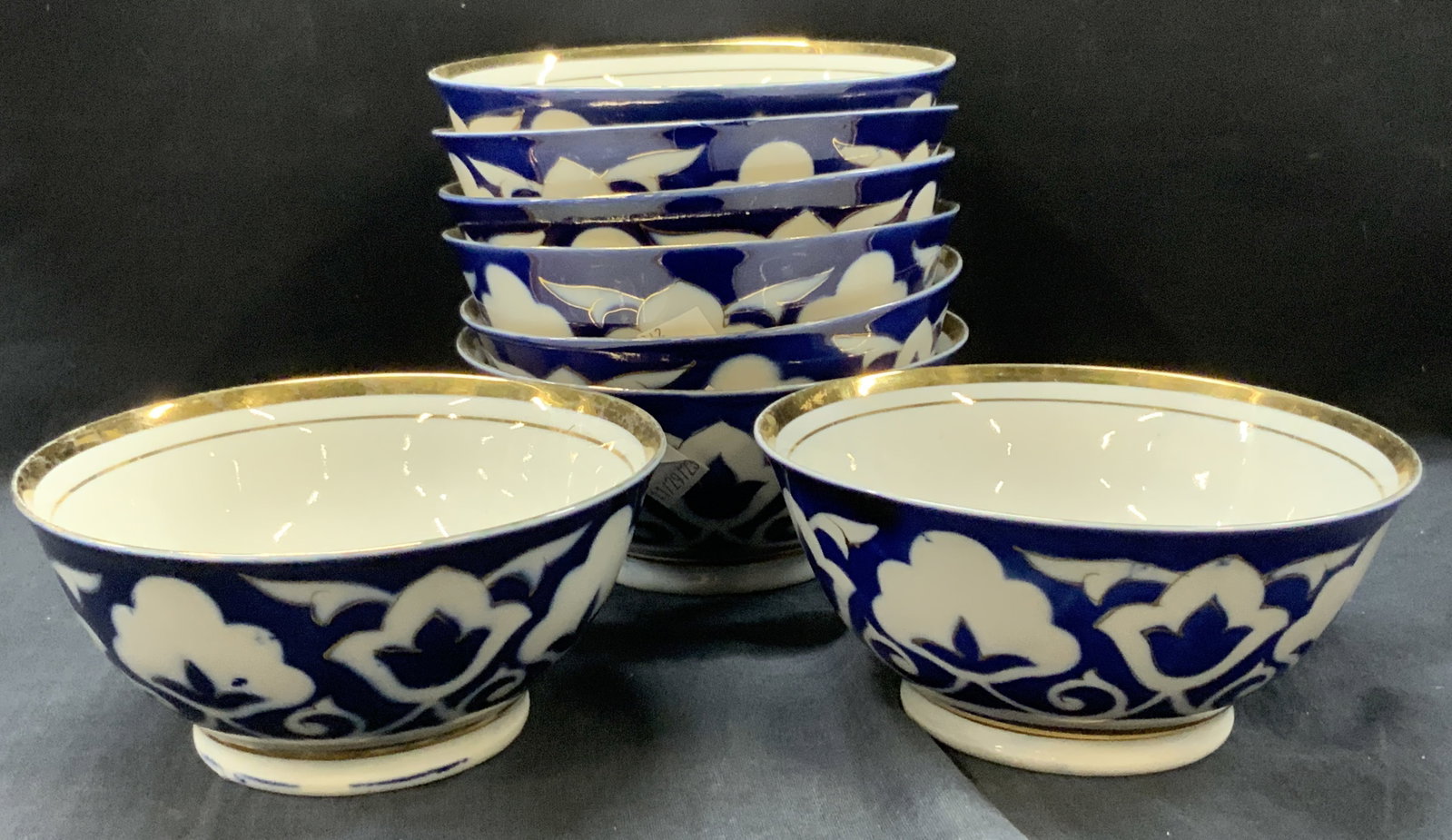 Set 8 Stamped Gilt Porcelain Asian Bowls: Set of 8 porcelain bowls with gilt rims and blue Asian floral deigns on exterior, stamped on underside illegibly. Approx 3 x 6 inches Moderate wearing to gilt and paint Job on exteriors Home decor, As