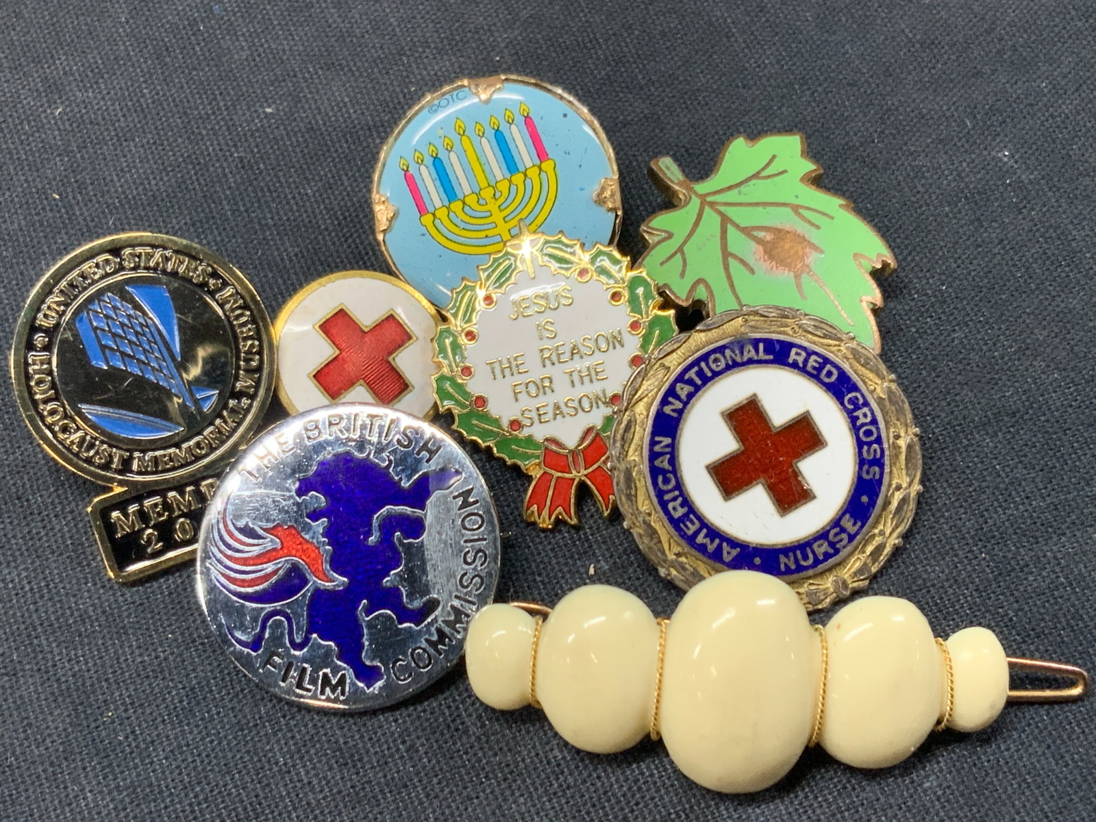 Lot 8 Vtg Enamel Pins, Religious & More: Lot of 8 vintage enamel pins. Some religious, with a holocaust memorial Museum member pin. 1 pin with a menorah, 1 in the shape of a leaf, another from the Red Cross and more. Largest being 2 inches l