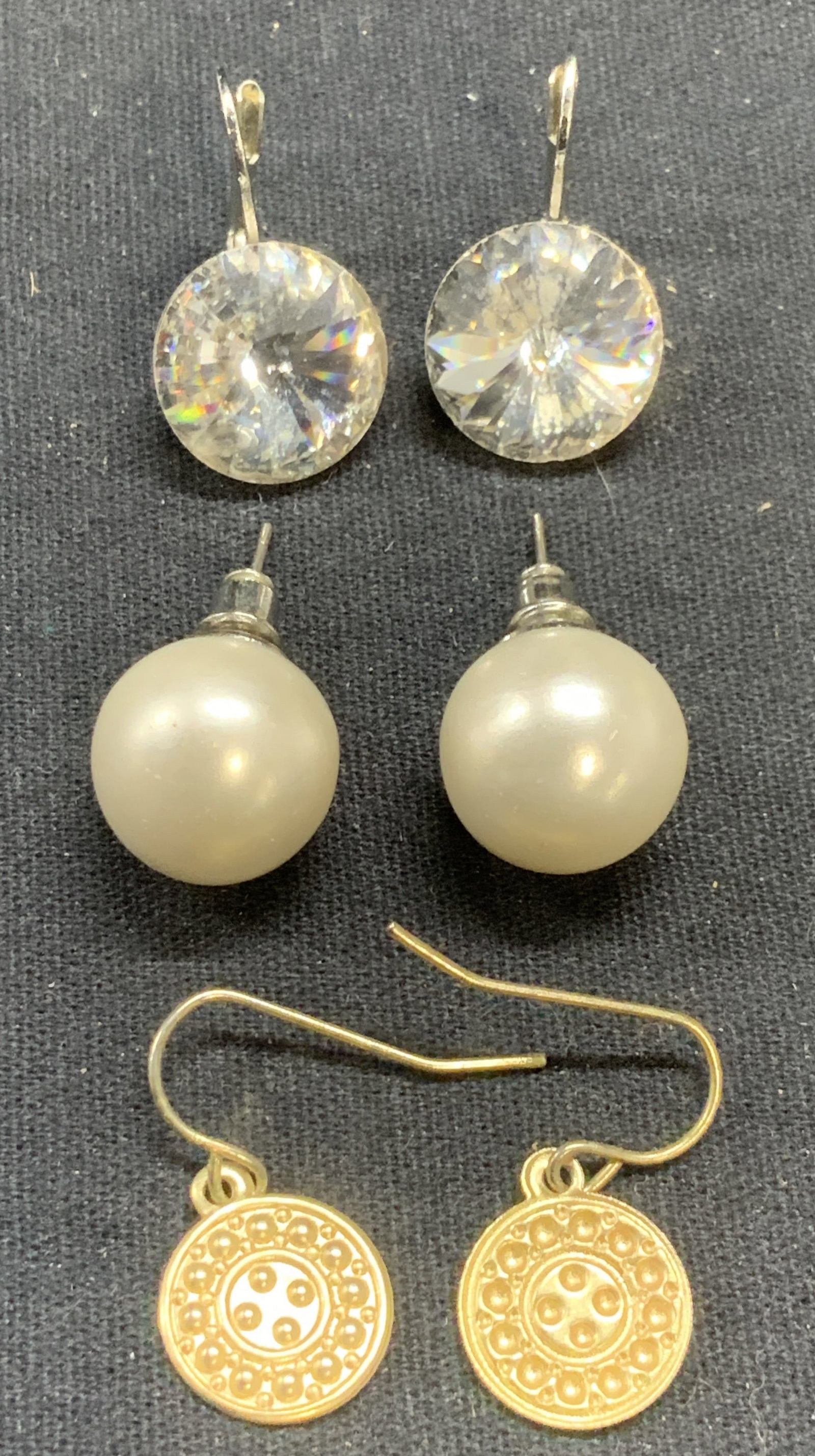 Lot 3 Crystal, Faux Pearl, Gold Tone Earrings: Lot of 3 pairs of crystal stud, faux pearl stud, and gold tone disc earrings. Largest measure approx. 5/8 inches wide. Some surface wear including scratching observed to all pieces. Estate jewelry, co