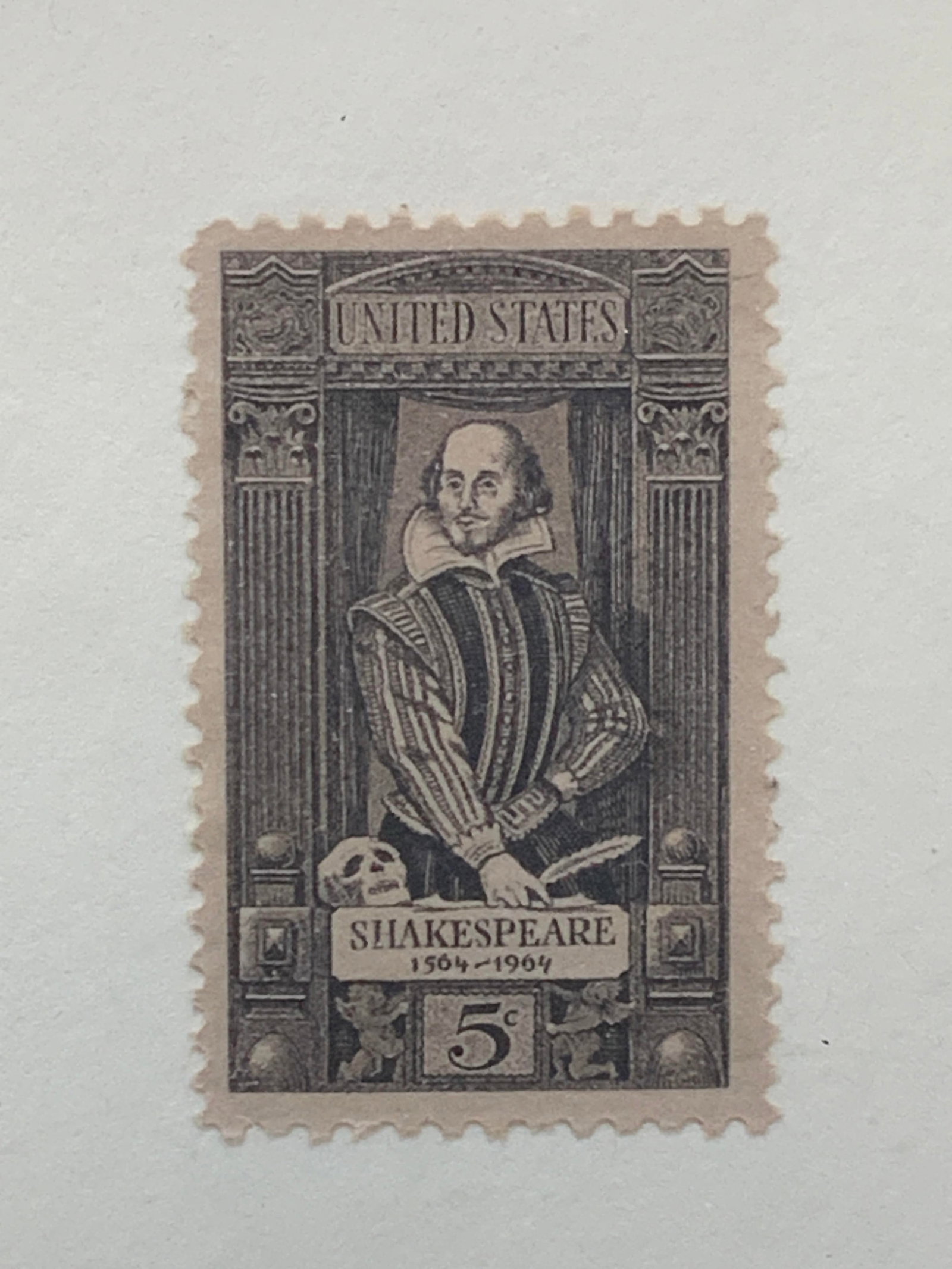 Framed Shakespeare Postal Stamp: Framed postal stamp, reading United States, 5 cents, Shakespeare with a depiction of the writer. Framed in a gold leafed wooden frame with white paper backing. Approx 6.5 x 5 inches window measures 4.