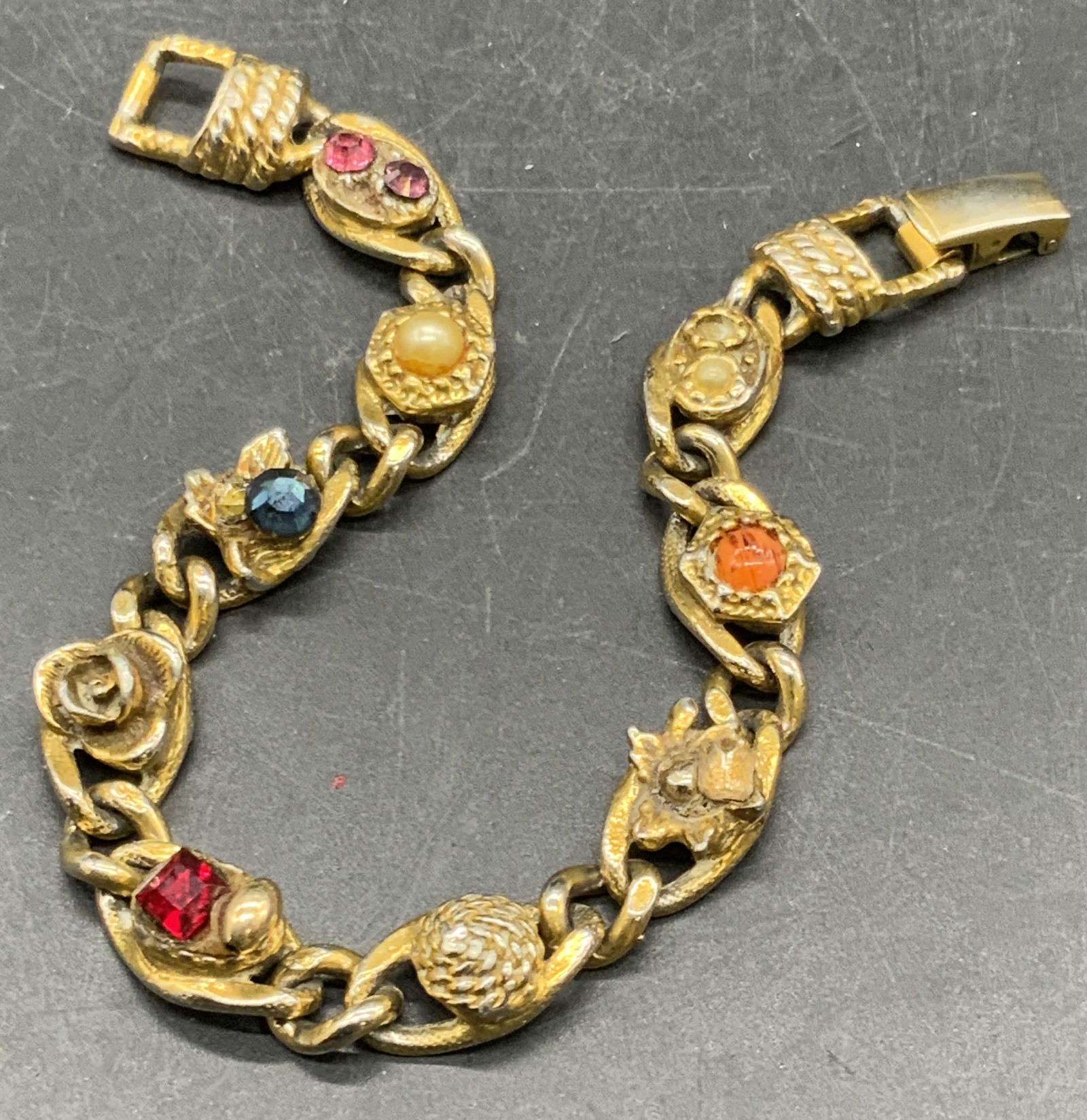 Vtg GOLDETTE Crystal & Costume Cabochon Bracelet: A gold tone bracelet featuring multicolored faceted crystals, pearlescent beads, and costume cabochons. Box clasp closure marked GOLDETTE NYC. Measures approx. 7 inches in length. Some surface wear pr