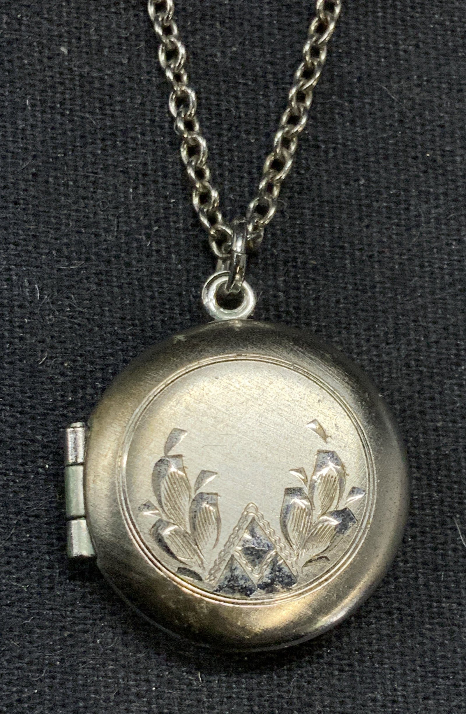Anson Sterling Silver Locket Pendant Necklace: Anson sterling silver necklace with locket pendant. Etched botanical motif on locket. Signed on clasp and marked sterling. Drop length approx. 12 inches. Locket measures approx. .75 inches wide. Total