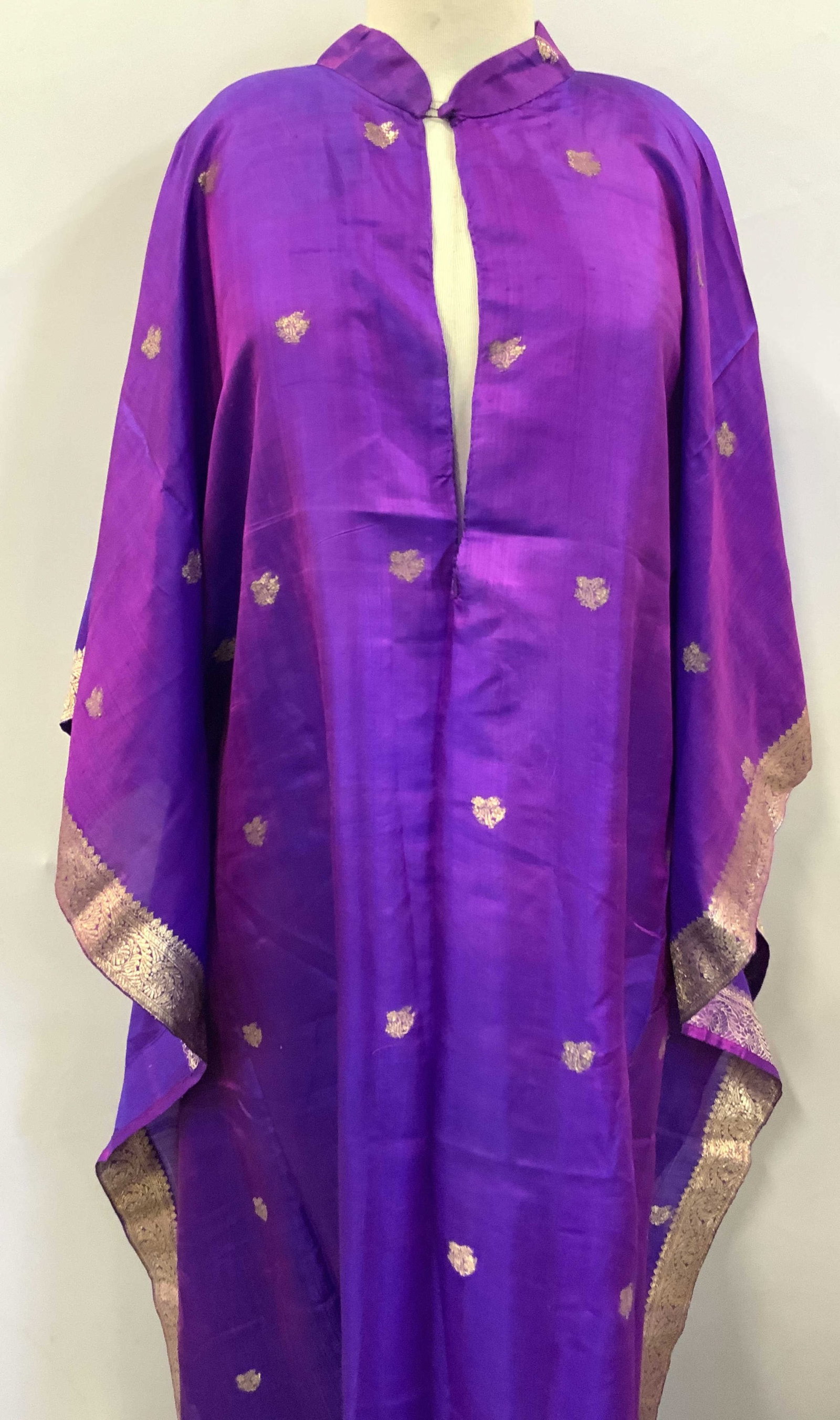 Purple Silk Embroidered Kaftan: Purple toned Kaftan, possibly silk with gold threaded embroidery on sleeves and throughout kaftan. Approx 55 inches long, 29 inches across and sleeves are approximately 8 inches long. Indian Kaftan, s