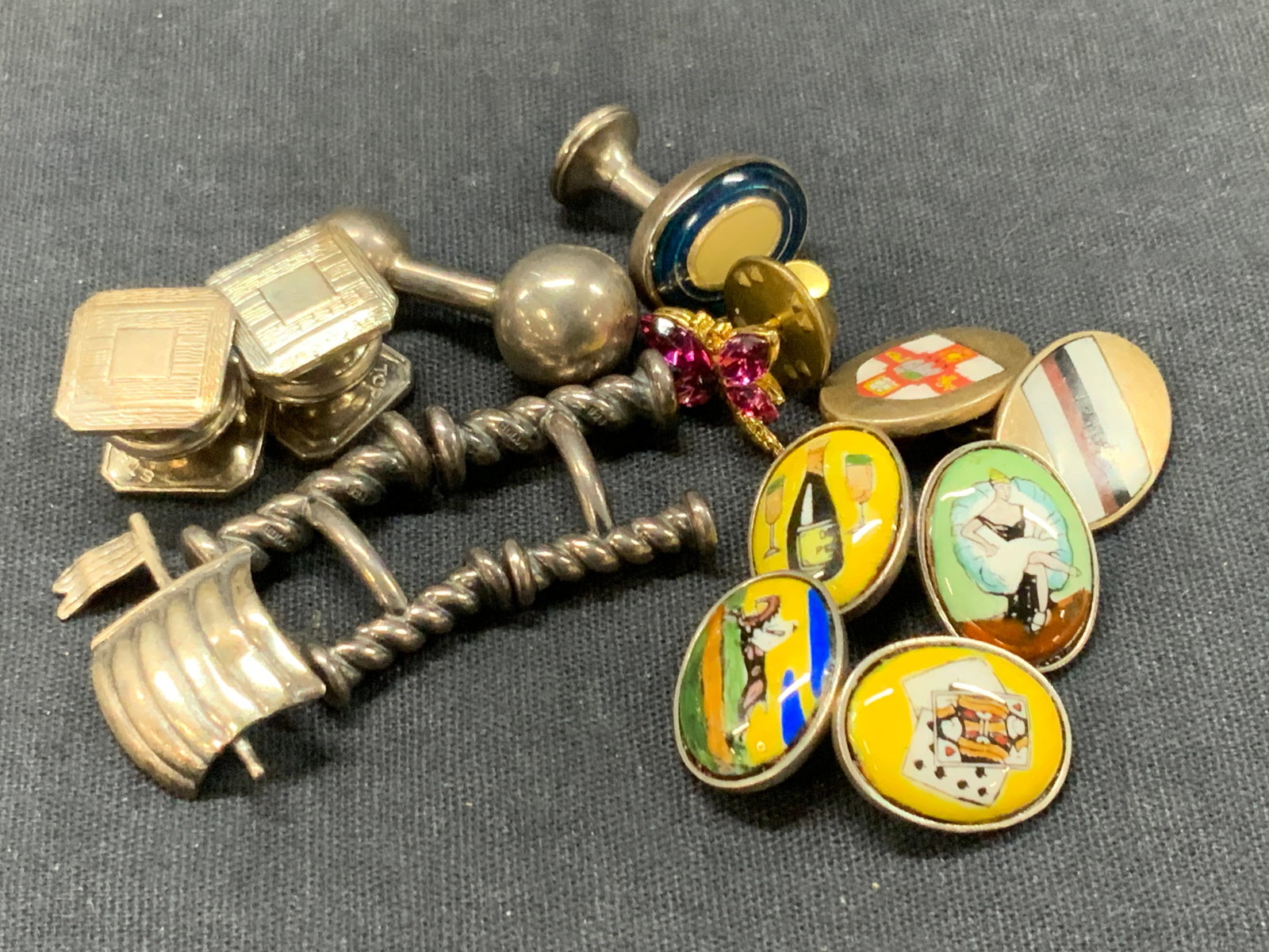 Lot 9 Vtg Sterling Silver Cufflinks: Lot of 9 cufflinks. 3 pairs marked sterling, with spirals, and lithograph images of dancers, wine, playing cards and, 3 single cufflinks with enamel centers and flags. And 1 sterling silver sail from 