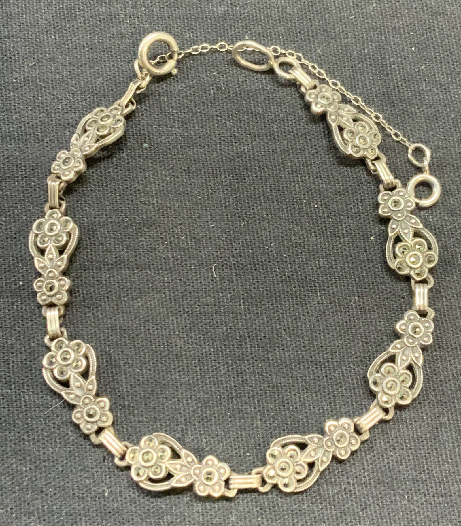 Sterling Silver & Marcasite Flower Bracelet: Sterling silver and Marcasite decorated flower motif bracelet. Marked sterling. Measures approx. 7 inches long, 9 inches long with extender. Total weight 8.3 grams. Some surface wear including scratch