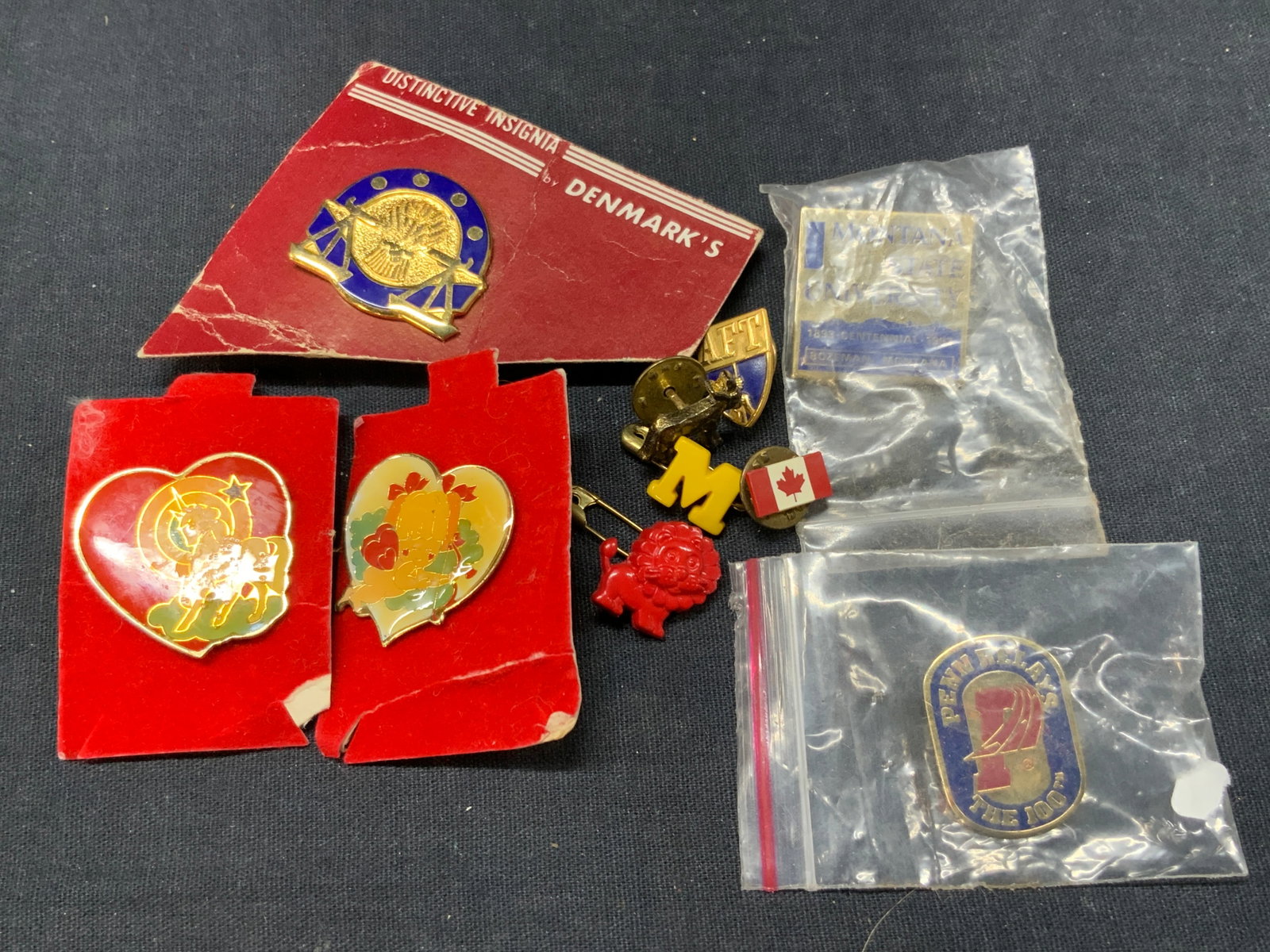 Lot 10 Vtg Lapel Pins, Universities and More: Lot of 10 vintage pins. Enamel and metal with 2 vintage pins of a unicorn and a Cupid. 1 brass donkey pin. 1 plastic m and lion pin and 1 gold toned enamel AFT pin. 1 enamel pin with a gold toned scal