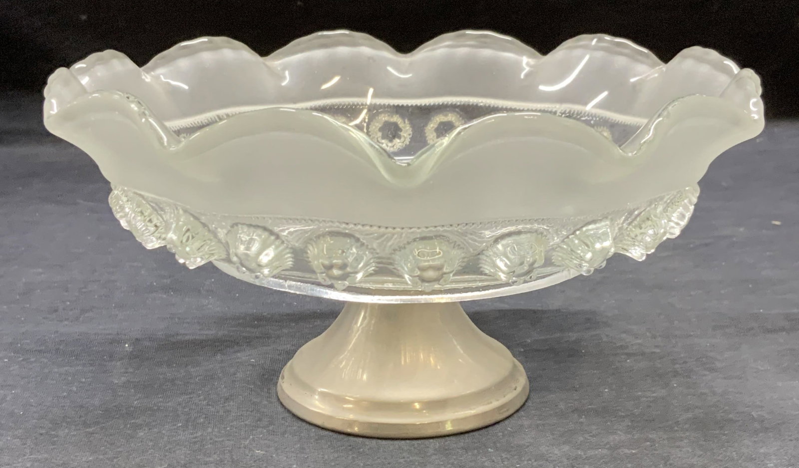 Vintage Footed Silver Tone Glass Bowl: Vintage silver tone footed glass bowl with raised floral motif. Scalloped rim. Measures approx. 7.75 x 3.75 inches. Some surface wear including scratching observed. Glass bowl, floral bowl, silver ton