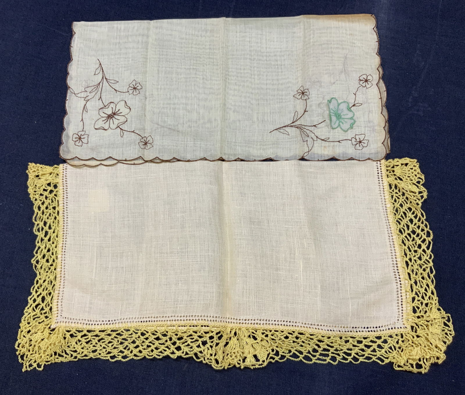 Lot 2 Vntg Floral & Crocheted Linens: Lot of 2 vintage linens. 1 with flower embroidery on corners in a yellow tone and another linen Handkerchief with a crocheted lace edge, approx 12 x 12 inches Moderate blemishes and wearing to linens