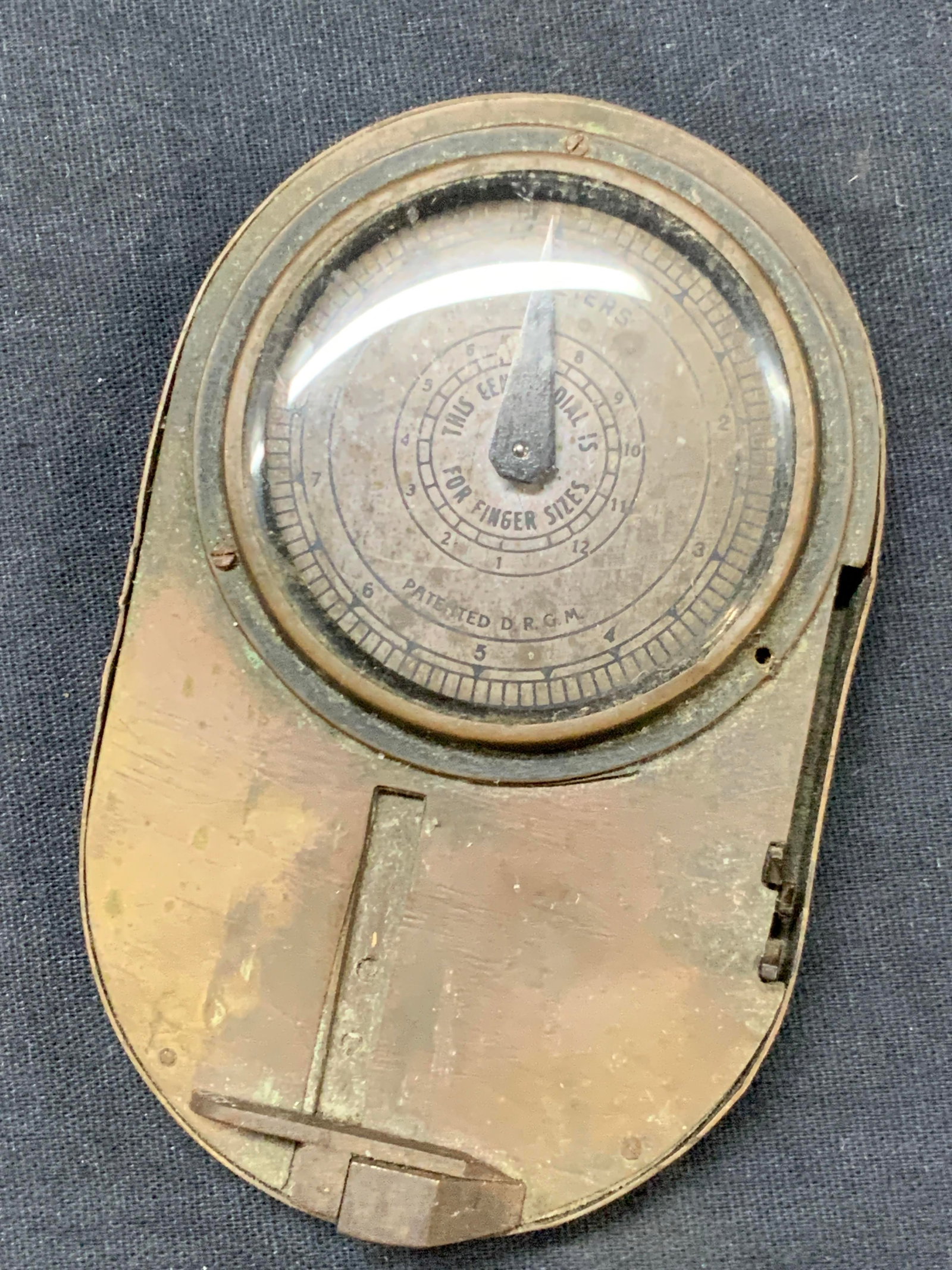 Vntg Brass Millimeter Gauge & Ringer Sizer, Germany: Vintage, possibly Antique Marked on backside, made in Germany. Brass made Millimeter gauge and ring sizer. Approx 4 x 2.5 inches Moderate wearing to brass ware exterior throughout, Brass wares, brass 