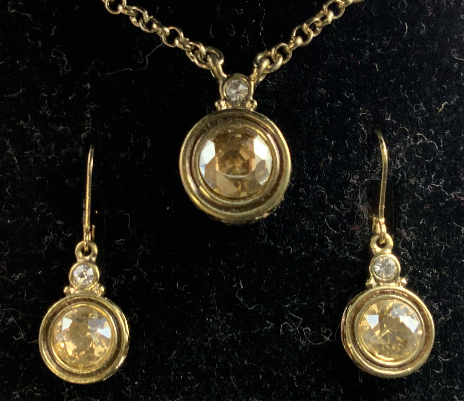 DILLARDS Scroll Crystal Earrings & Necklace, Boxed: A boxed Dillards Scroll jewelry set consisting of earrings and a necklace. Crafted from gold tone metal and decorated with yellow hued and colorless crystals. Lobster claw clasp closure to the necklac