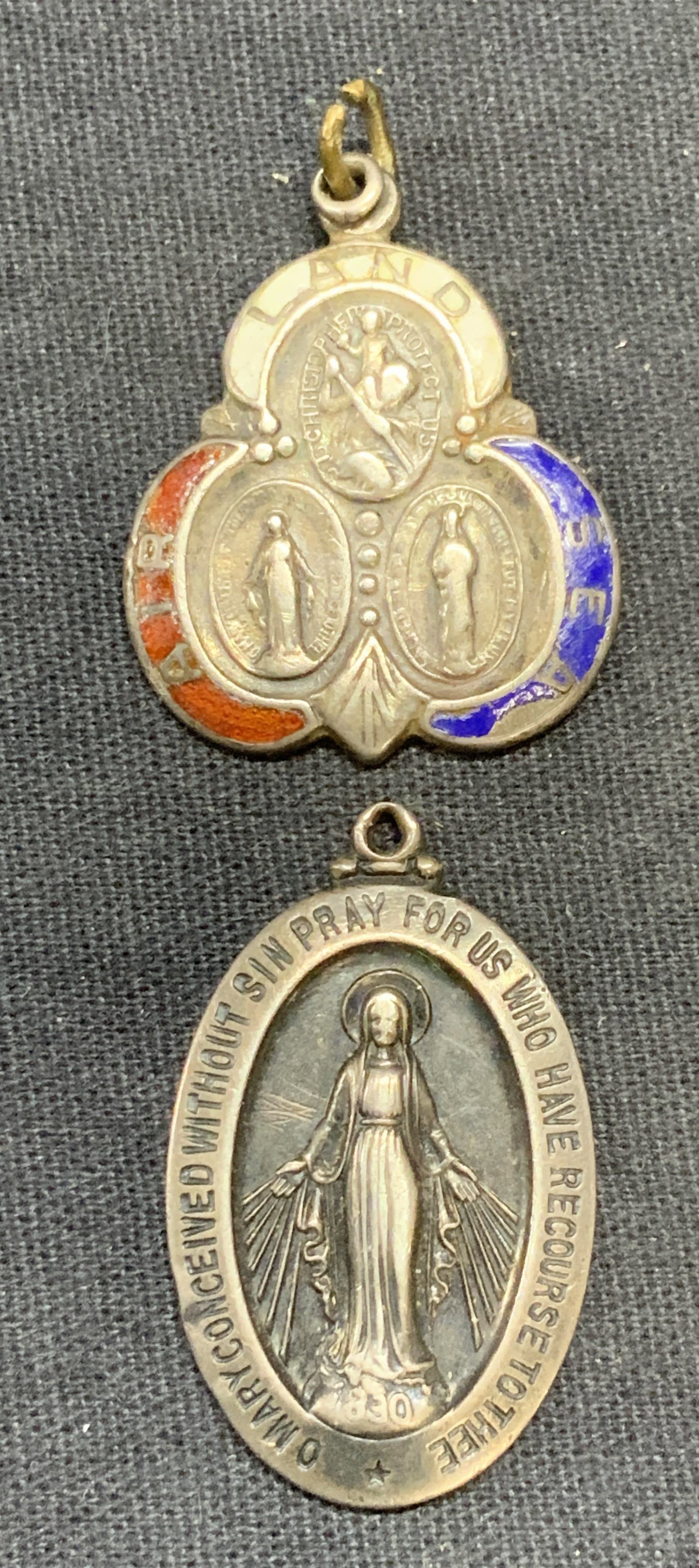 Lot 2 Sterling Silver Virgin Mary Pendant +: Sterling silver Virgin Mary catholic religious pendant. Marked sterling. Measures approx. 1.25 x .75 inches. Sterling silver and enamel Catholic religious motif pendant. Tests for sterling using Purit