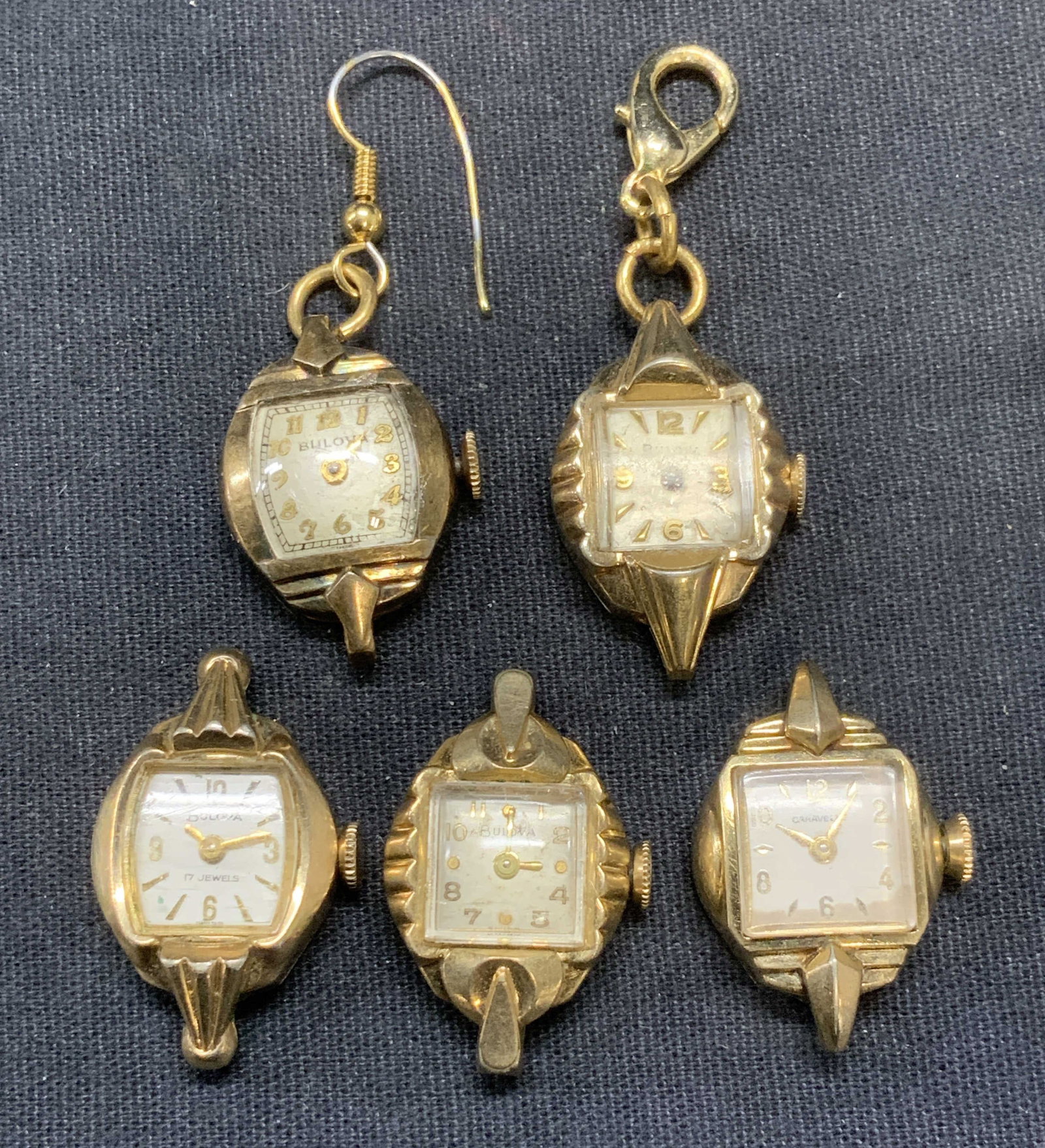 Lot 5 Vintage Bulova & Caravelle Watch Pendants: Lot of 5 vintage gold tone Bulova and Caravelle watch pendants. Signed on faces. Sizes vary slightly, approx. 1.25 inches long. Not tested for function. Some surface wear including scratching observed