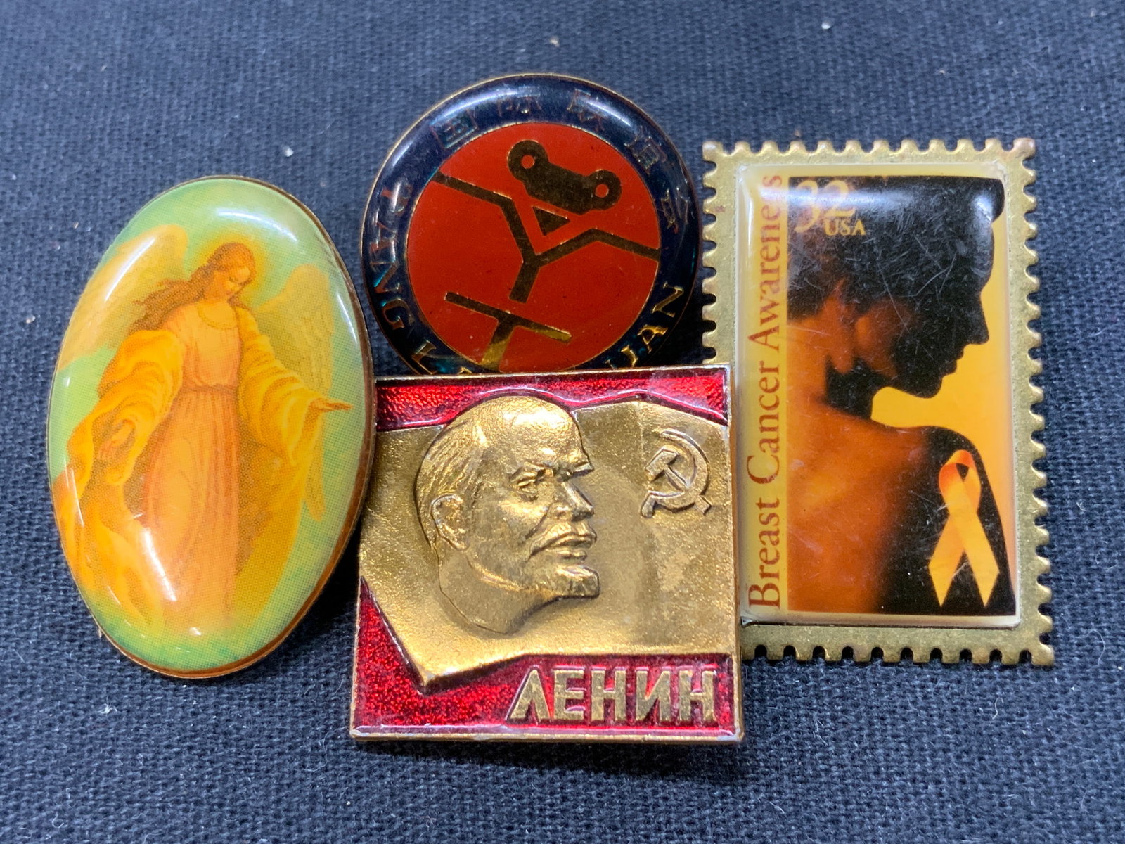 Lot 4 Vntg Lapel Pins, 15k Gold, Religious & More: Lot of 4 vintage lapel pins. 1 depicting an Angel with brass backing. 1 marked Tang lang Quan, marked 1991, another reading breast cancer awareness, in the shape of a stamp, 1997 and 1 pin with an ima