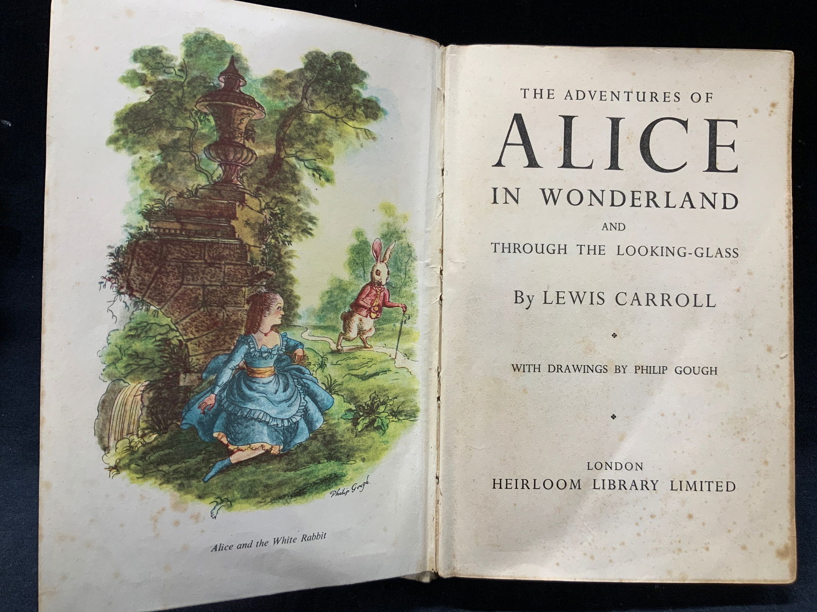Vntg Alice Through The Looking Glass Illustr. Book: Vintage possibly antique Alice in wonderland through the looking glass. Published by Heirloom library limited, complete with 7 full color plates hardcover book with fabric in blue and white with image