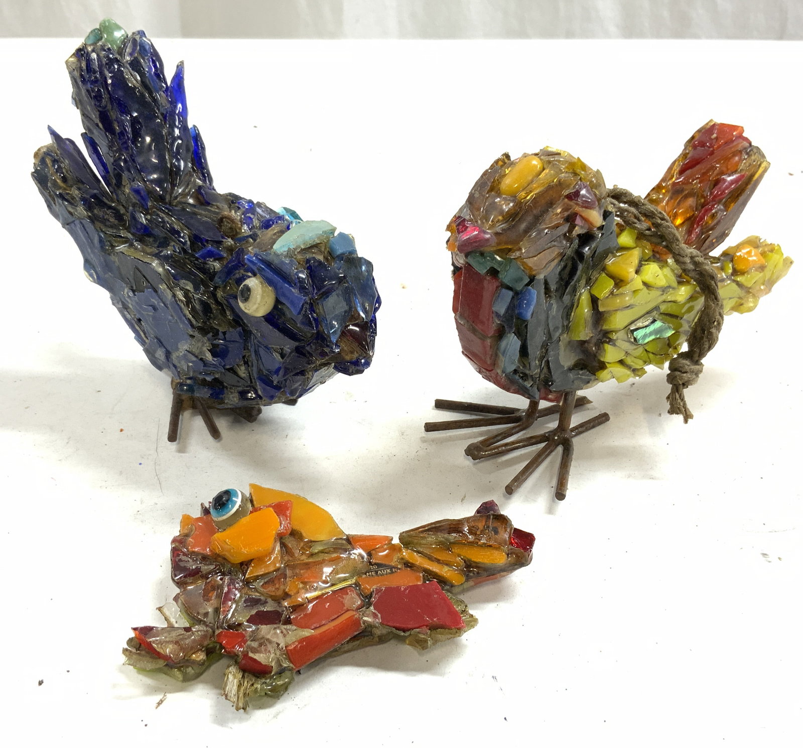 Lot 3 Glass Mosaic & Metal Bird Sculptures: Lot includes 3 bird sculptures. Each are hand crafted from glass & metal. Each piece has glass mosaic structure. Two sculptures have metal feet. One piece has rope to hang sculpture. Largest sculpture