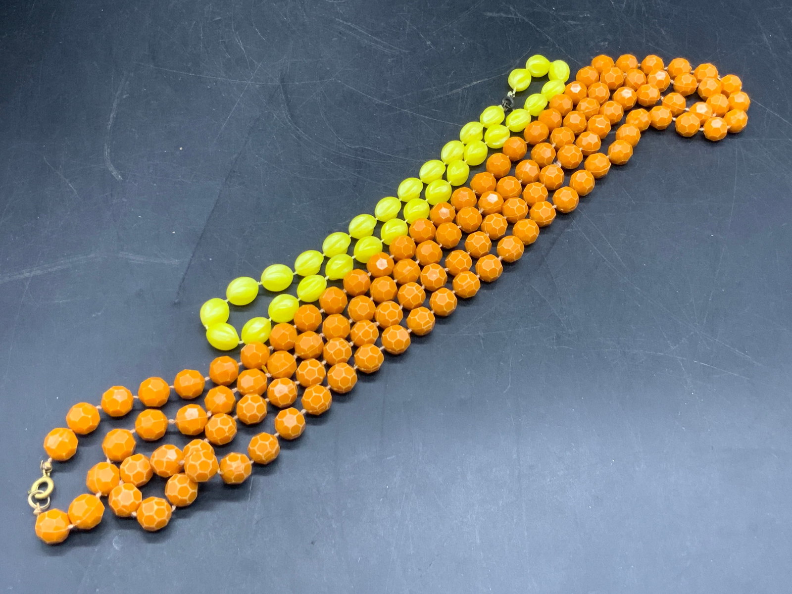 Lot 2 Orange & Yellow Beaded Necklaces, Jewelry: Two composite beaded necklaces. One necklace features faceted orange beads and the other features yellow beads. Both pieces secure with C Spring clasp closures. Orange necklaces measures 55 inches in 