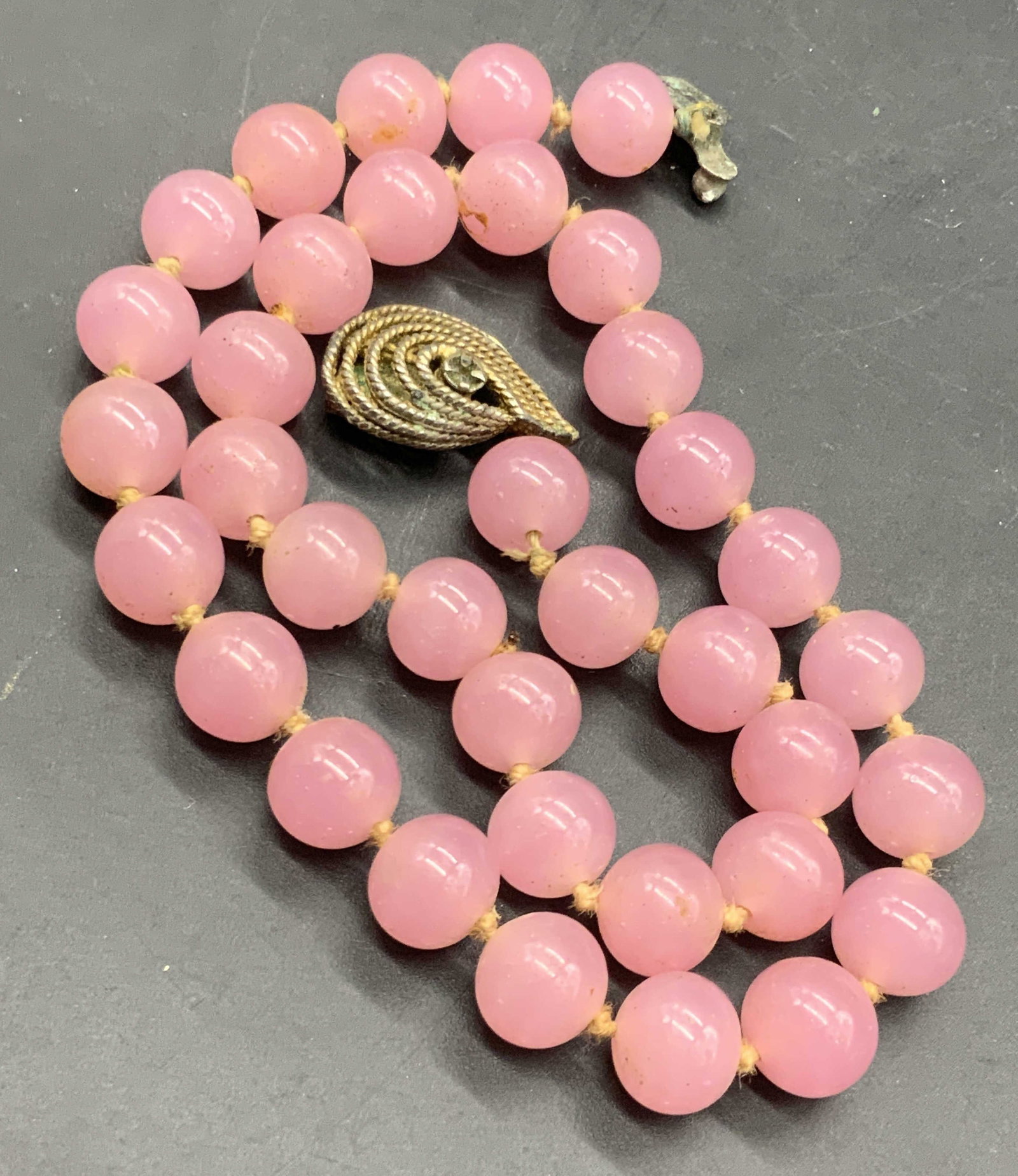 VOUGE JLRY Pink Glass Beaded Choker Necklace: A vintage pink glass beaded choker necklace with a metal teardrop form box clasp closure. Signed VOUGE JLRY on box clasp closure. Necklace length measured end to end approx. 15.25 inches. Missing crys