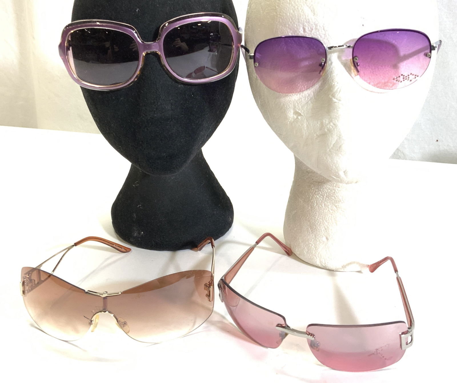 4 Fashion Sunglasses, CHRISTIAN DIOR & More: 4 fashion sunglasses. Frameless amber lens sunglasses are Christian Dior Diorella, made in Austria. Lens has fissures around nose arc. Slightly curved frame , 6 in. Wide x 2 in. Frameless pink lens su