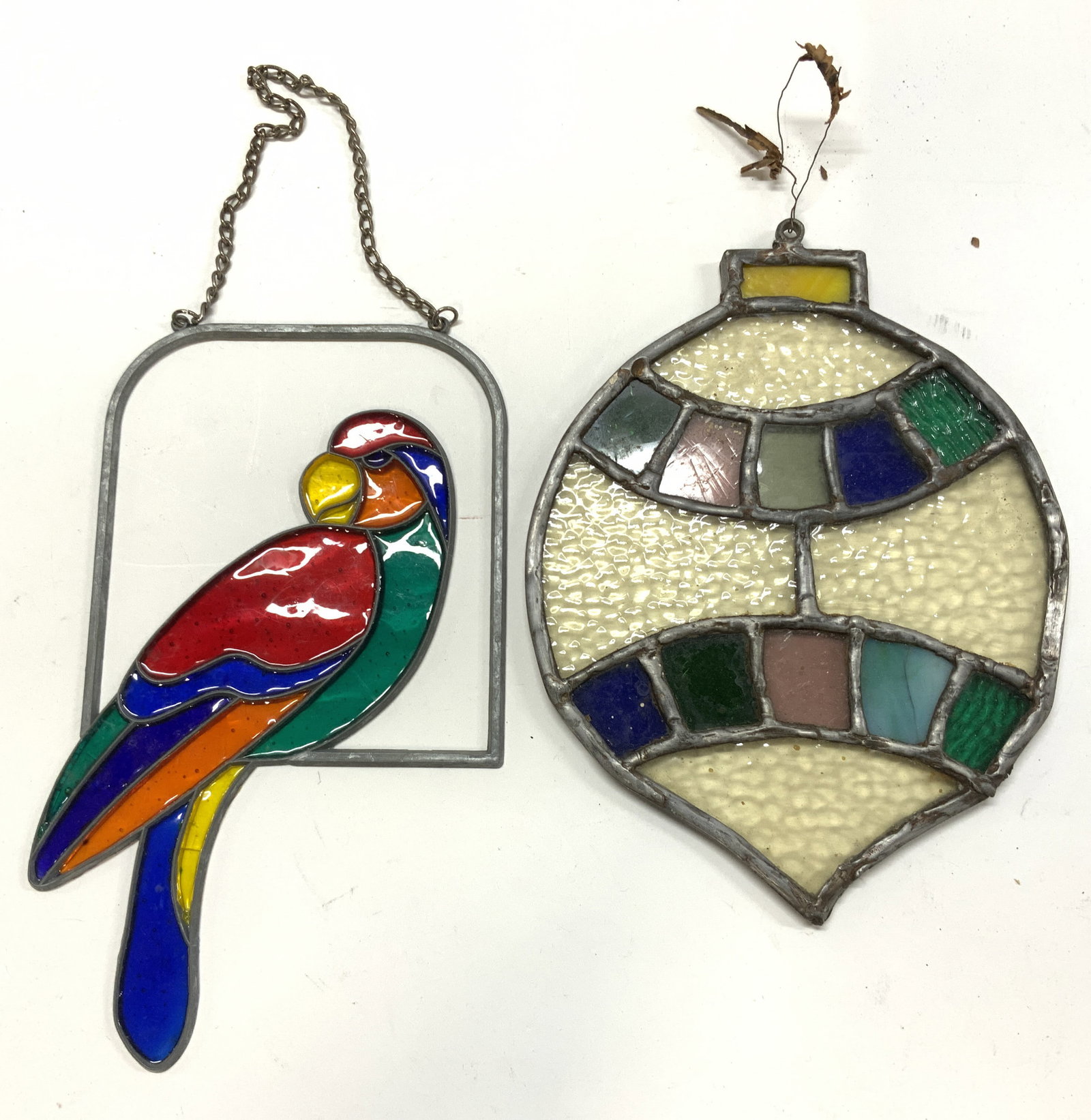 Lot 2 Stained Glass & Slag Glass Window Catchers: Vintage parrot stained glass window catcher ( 12.5 in. Long with hanging chain x 4.75 in. W) and tree ornament slag glass window catcher ( 8 x 6 in.) . This piece is thick and has weight. Crack to one