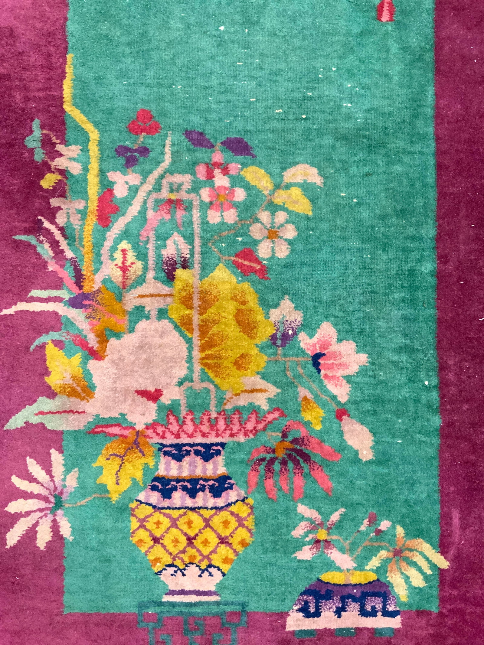 Vintage Handmade Chinese Art Deco Wool Rug: Rug is handmade and wool. Piece is vintage. Rug has magenta edges & green center. Piece has multi toned floral, leaf & vase detail. Rug measures approximately 51 inches ling 29 inches wide. Rug, carpe