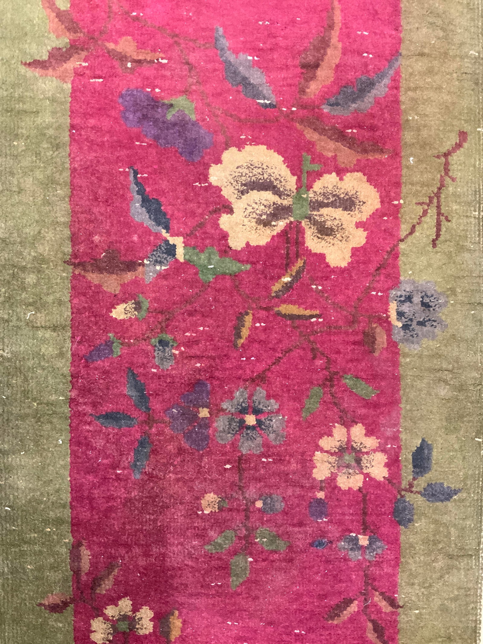 Vintage Handmade Chinese Art Deco Wool Rug: Rug is handmade and wool. Piece is vintage. Rug has olive edges & magenta center. Piece has multi toned floral & leaf detail. Rug measures approximately 47 inches ling 25 inches wide. Rug, carpet, are