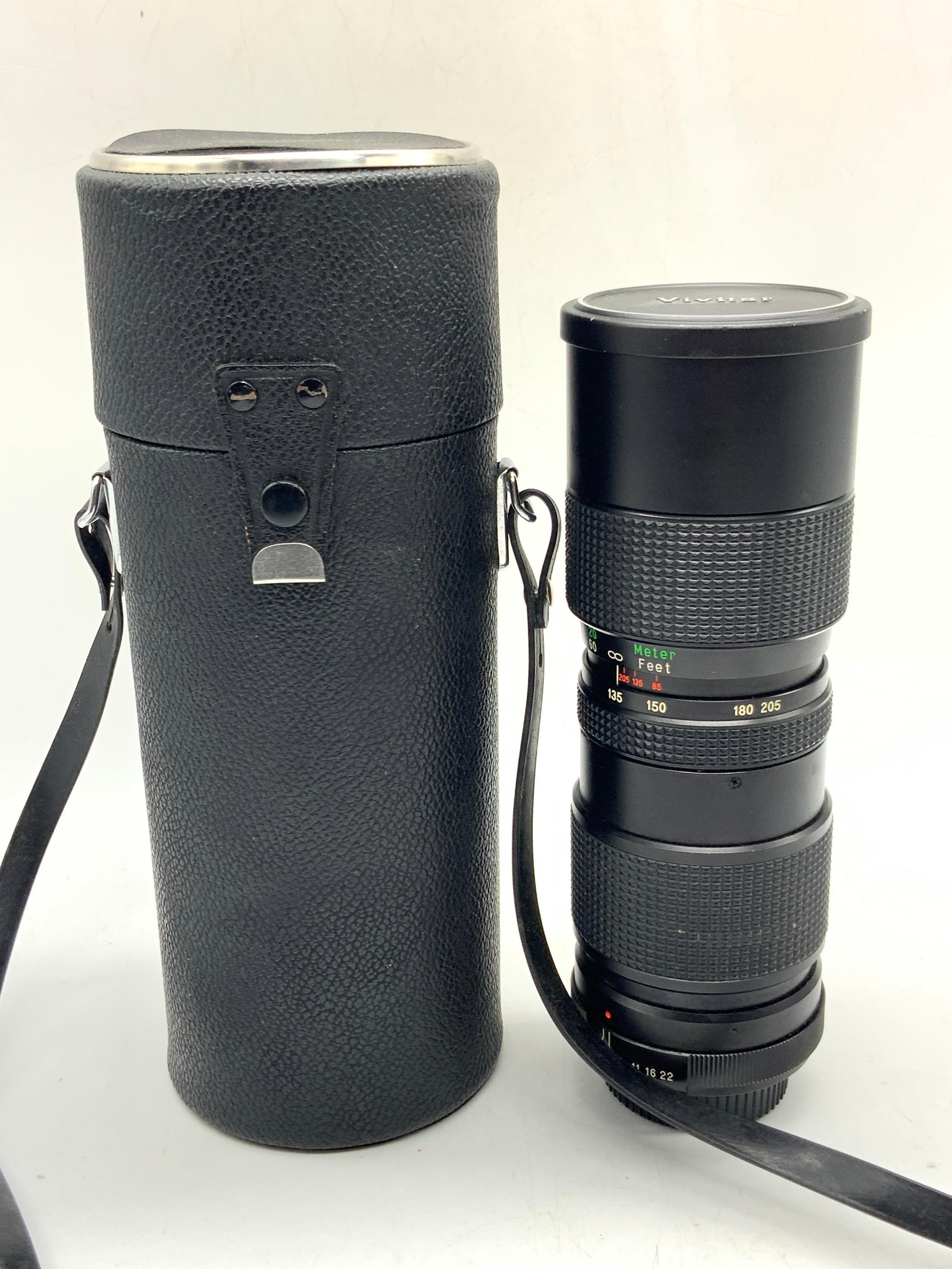Vivitar 85-205mm Auto Zoom Camera Lens W Case: A vivitar 85-205mm Auto Zoom Camera Lens with black leather carrying case. Lens is approx 8 inches long and 2.75 inch diameter and case is approx 10 inches long with strap length being 14 inches long 