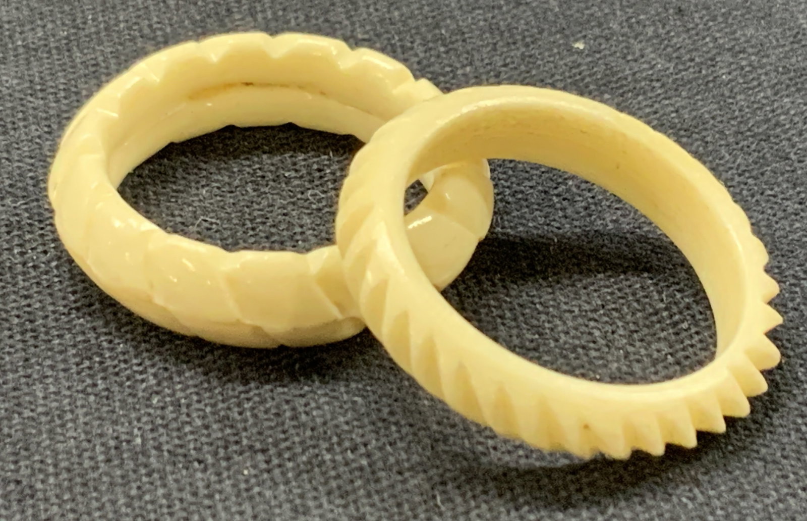 2 Carved Bone & Composite Rings: Lot of 2 off white rings. 1 made of carved bone with a spiral design, the other made of a hard composite material. Sizes 7.5 and 6.5 Minor wearing to rings. Vintage rings, bone rings. Rings. Ladies ri