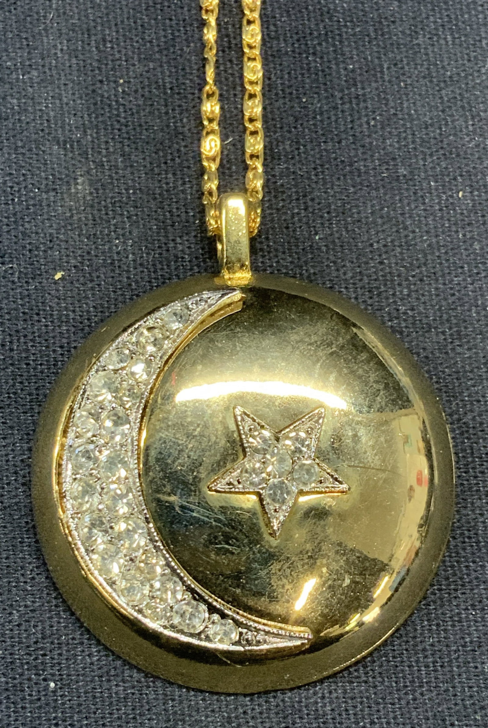 Gold Tn Star & Moon Crystal Pendant Necklace: Gold tone pendant necklace with crystal decorated Star and moon motif. Drop length approx. 7.25 inches. Pendant measures approx. 1.5 inches wide. Some surface wear including scratching observed. Estat