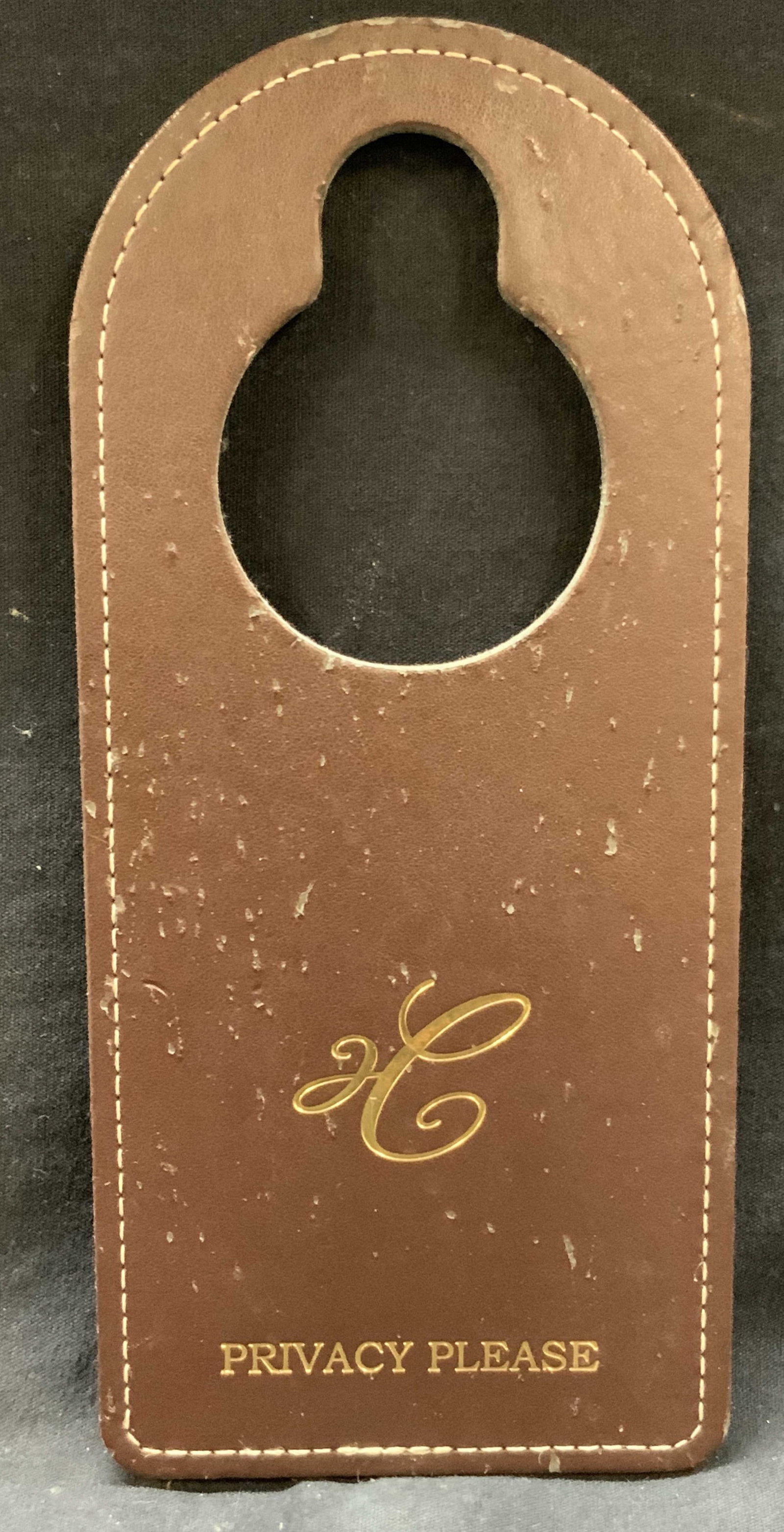 Vntg Carlyle Hotel Room Leather Privacy Tag: Vintage leather made privacy room tag from the Carlyle hotel. Brown leather with gilt text and logo. Approx 9 x 4 inches Moderate wearing to leather tag and blemishes throughout due to age and use Lea