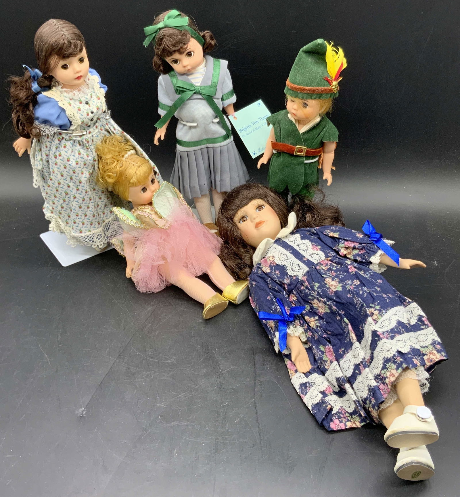 Lot 5 MADAME ALEXANDER Articulated Eye Dolls +: Four MADAME ALEXANDER composite dolls with articulated eyes. One doll has a tag which reads MADAME ALEXANDER Brigitta Von Trapp The Sound of Music Collection. Dolls wear multicolored fabric outfits. L
