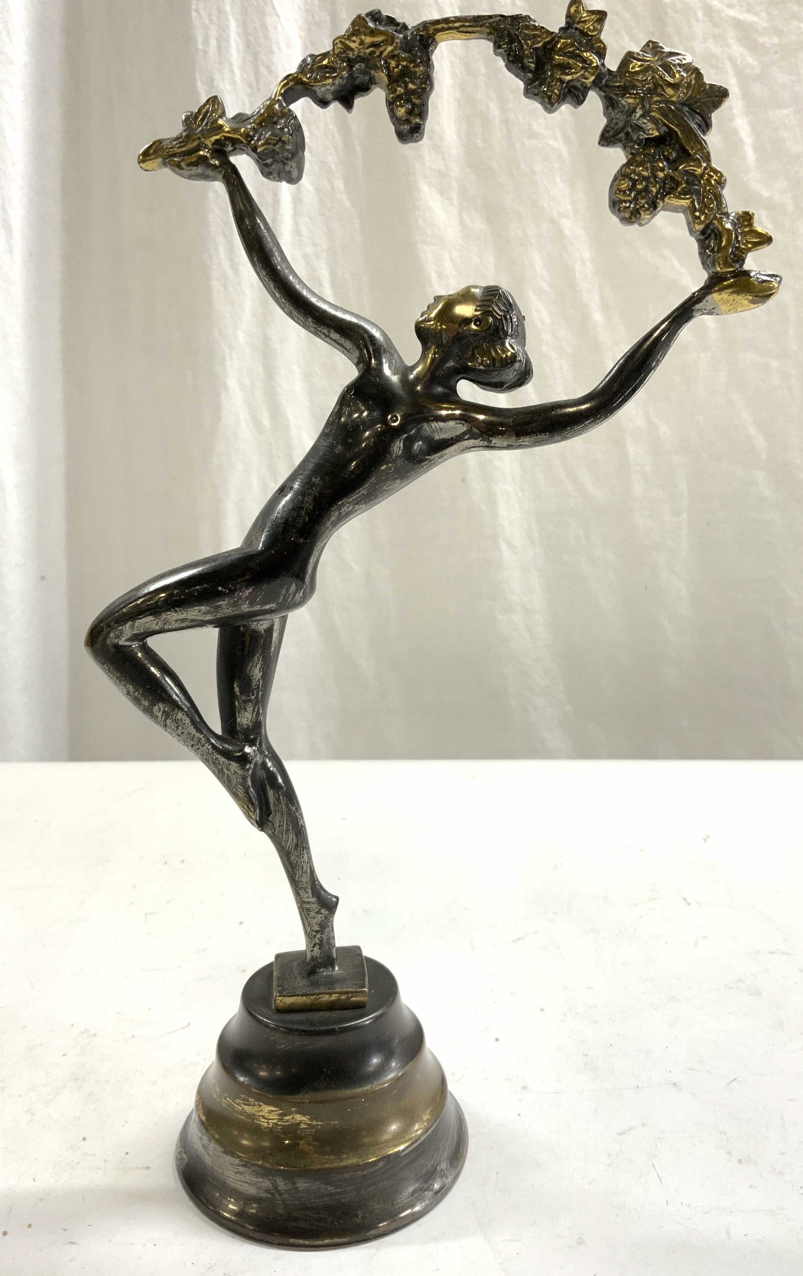Art Deco Gilt Metal Female Nude Dancer: Piece is gilt metal, possibly bronze. Figure depicts a female nude dancer with 1 leg raised. holding a grape and leaf vine overhead. Piece measures approximately 11 inches tall 6.5 inches wide 3 inche