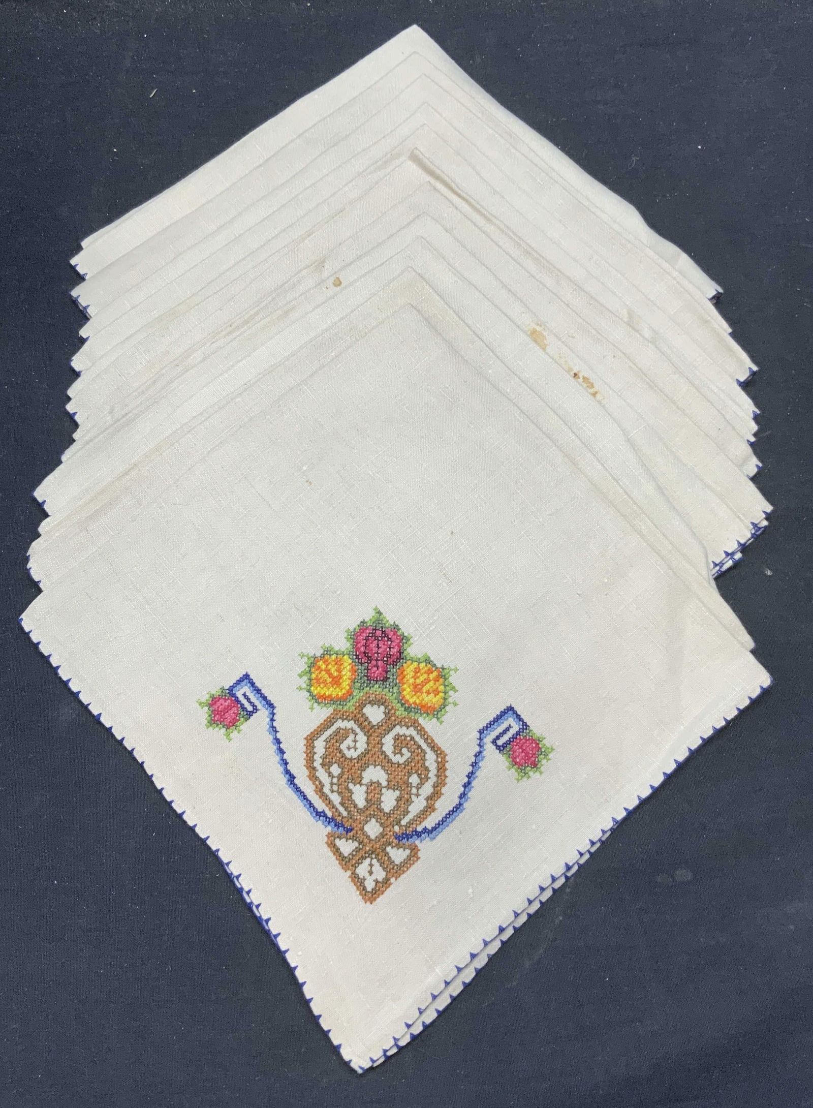 Set 11 Beige Linen Embroidered Floral Napkins: Set of 11 beige napkins. Embroidered cross stitch decoration with floral motif. Measure approx. 19 x 20 inches each. Material feels like linen. Some pieces have wear to material including blemishes ob