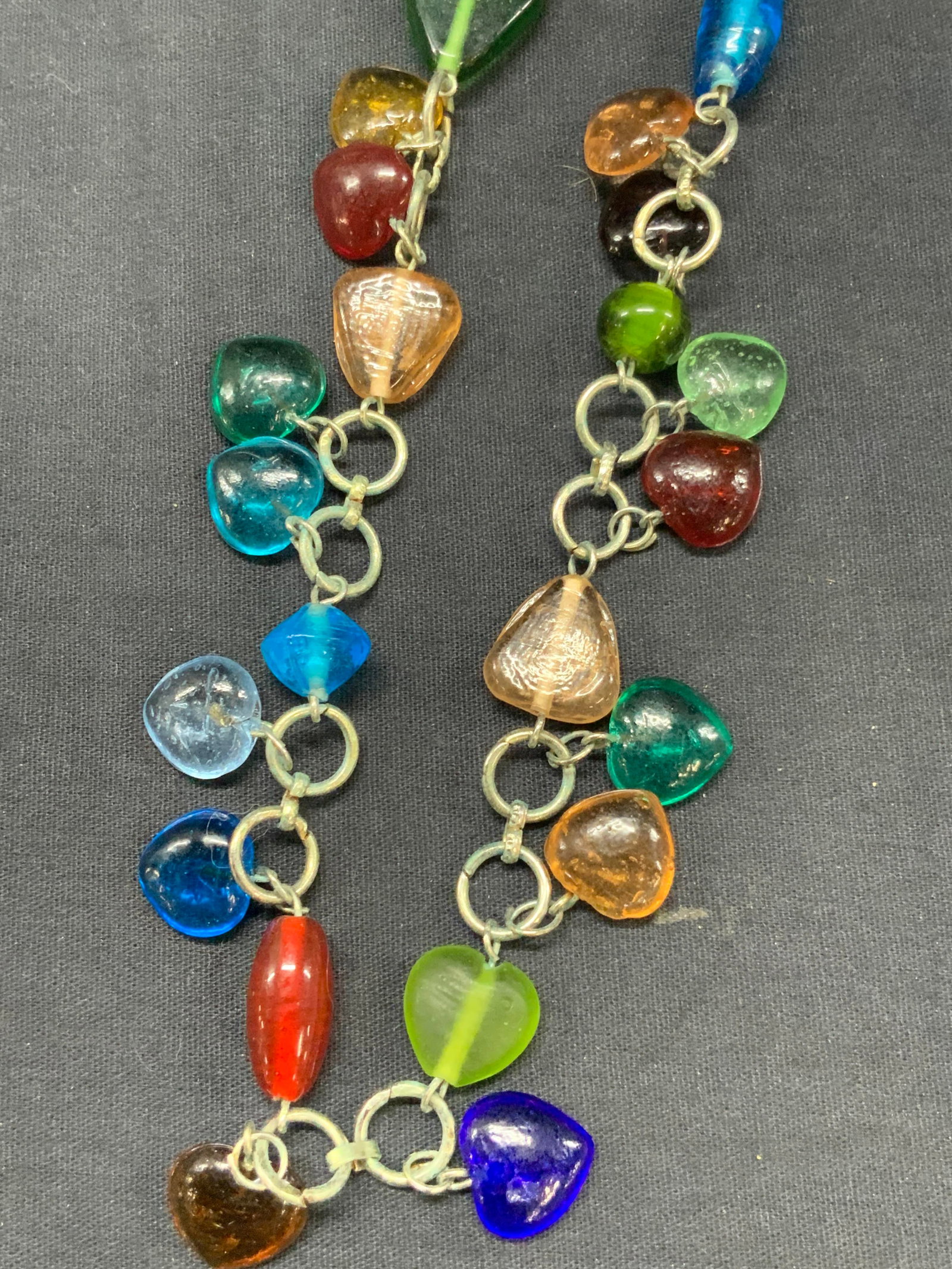 Art Glass Beaded Chain Accessory: Art glass beaded chain with heart shaped glass beads and other beads in differing colors affixed to white metal chain. Approx 18 inch drop Moderate wearing to glass and to chain Glass hear decor. Glas
