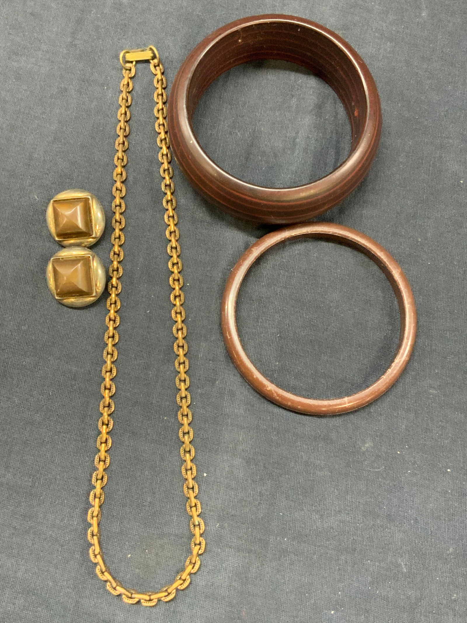 Lot 4 Copper & Wooden Jewelry, TRIFARI & More: Lot of 4 pieces do jewelry. 1 pair of silver plate TRIFARI clip on earrings with resin that resembles wooden in center approx 0.75 inches wide. 1 copper chain Necklace, at 8 inches long. 1 brown toned