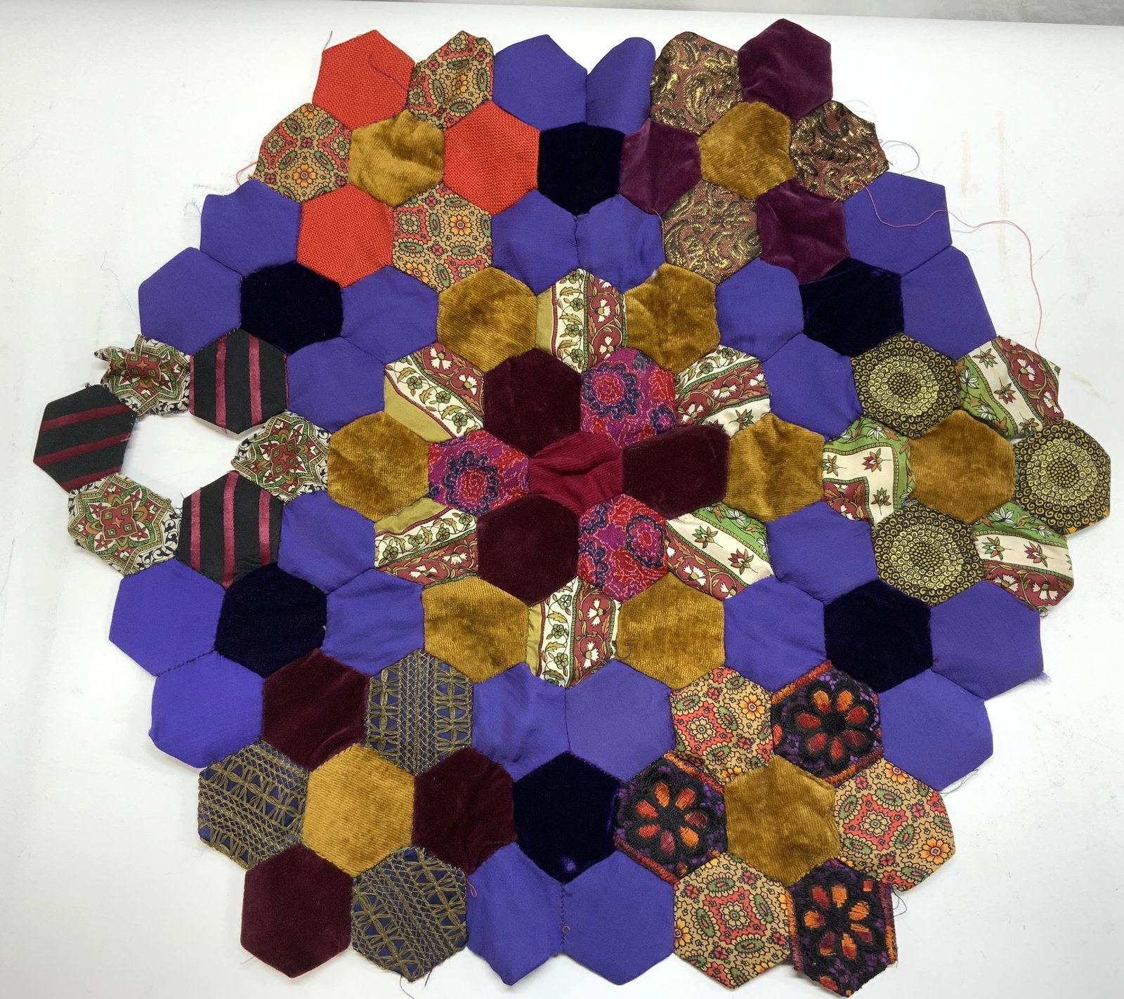 Handmade Hexagonal Paper Pieced Doily: Vintage handmade hexagonal paper pieced table decor/ doily/ wall decor. Lacks 1 hexagonal and needs repair . Vintage fabrics of velvet, silk, rayon, damask and jacquard. 28.5 in. X 24.5 in. Up cycle. 