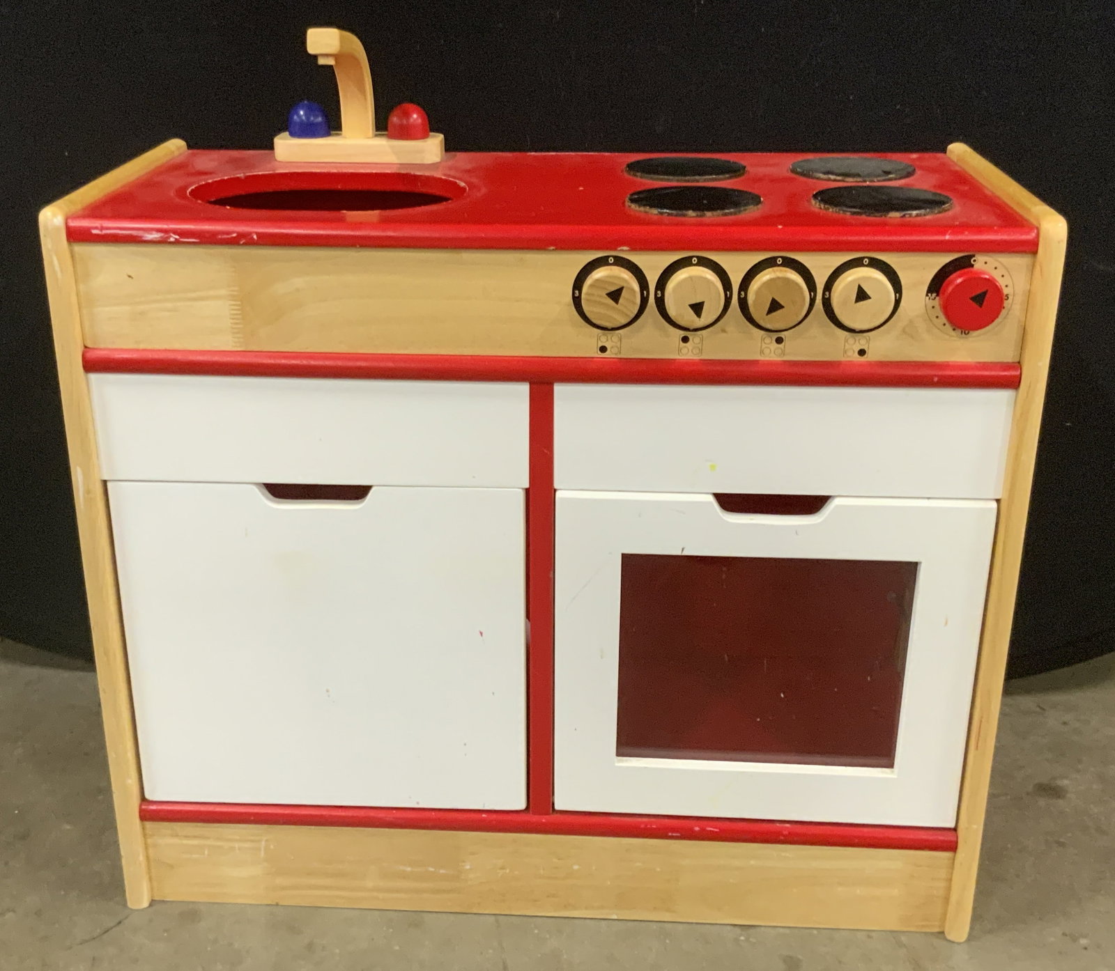 Red, White, & Brown Wooden Oven W/ Sink, Toy: A wooden oven and sink childrens toy. Crafted from wood and hard plastic materials. Red, white, brown, and black hues. Doors open to reveal storage. Measures approx. 30H x 30.75W x 26H in. Chipping, s