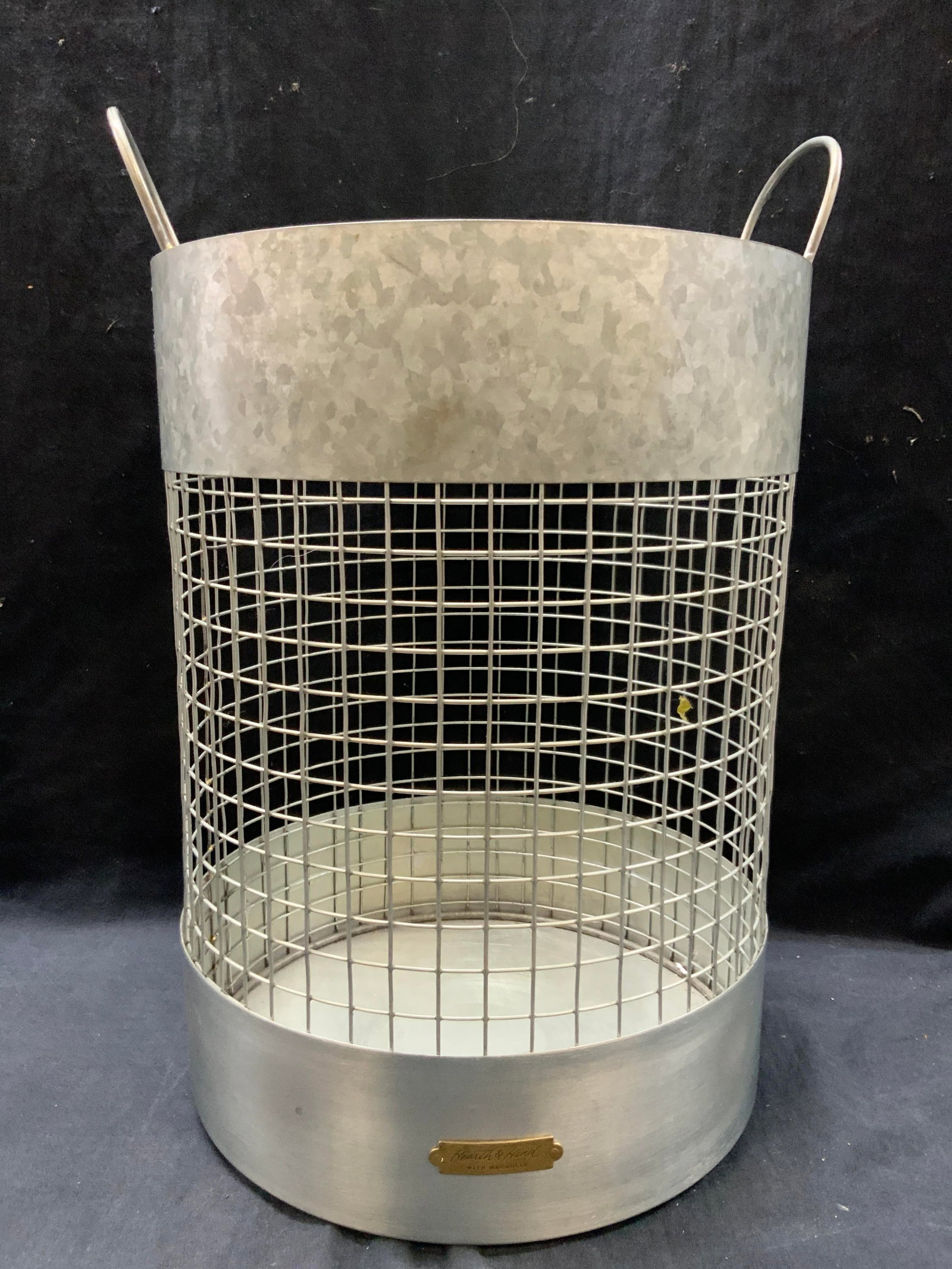 Sheet Metal Waste Basket, Health & Hand: Marked on basket, health and hand with magnolia. White sheet metal made waste bucket with side handles. Approx14 inches tall and 10 inch diameter. Moderate surface wearing to metal due to age and use.