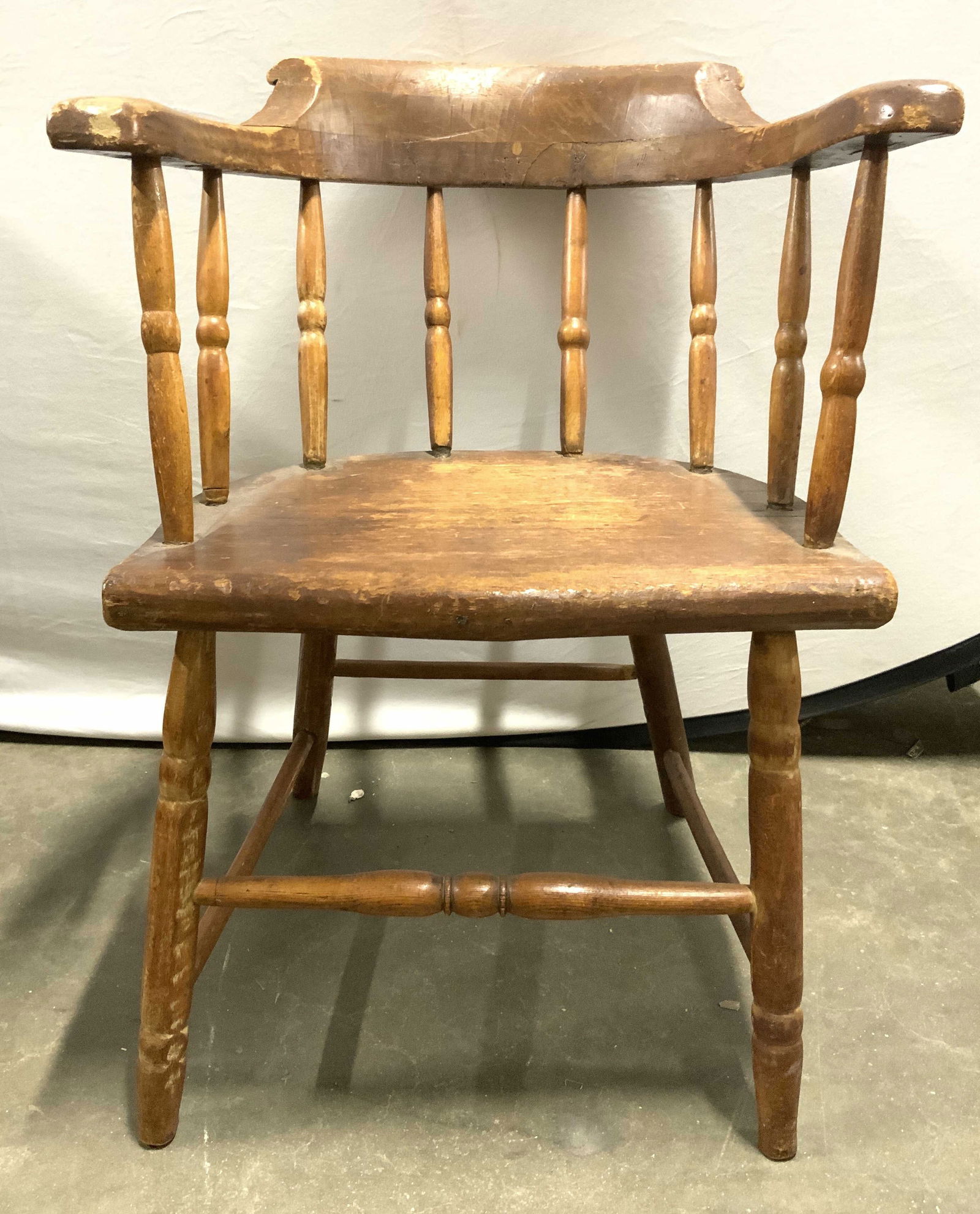 Vintage Carved Wooden Captains Chair: Chair is vintage and wooden. Piece has horse shoe form backrest. Chair includes cream toned seat cushion. Chair has 4 legs with stretcher in between. Chair measures approximately 28 inches tall 22 inc
